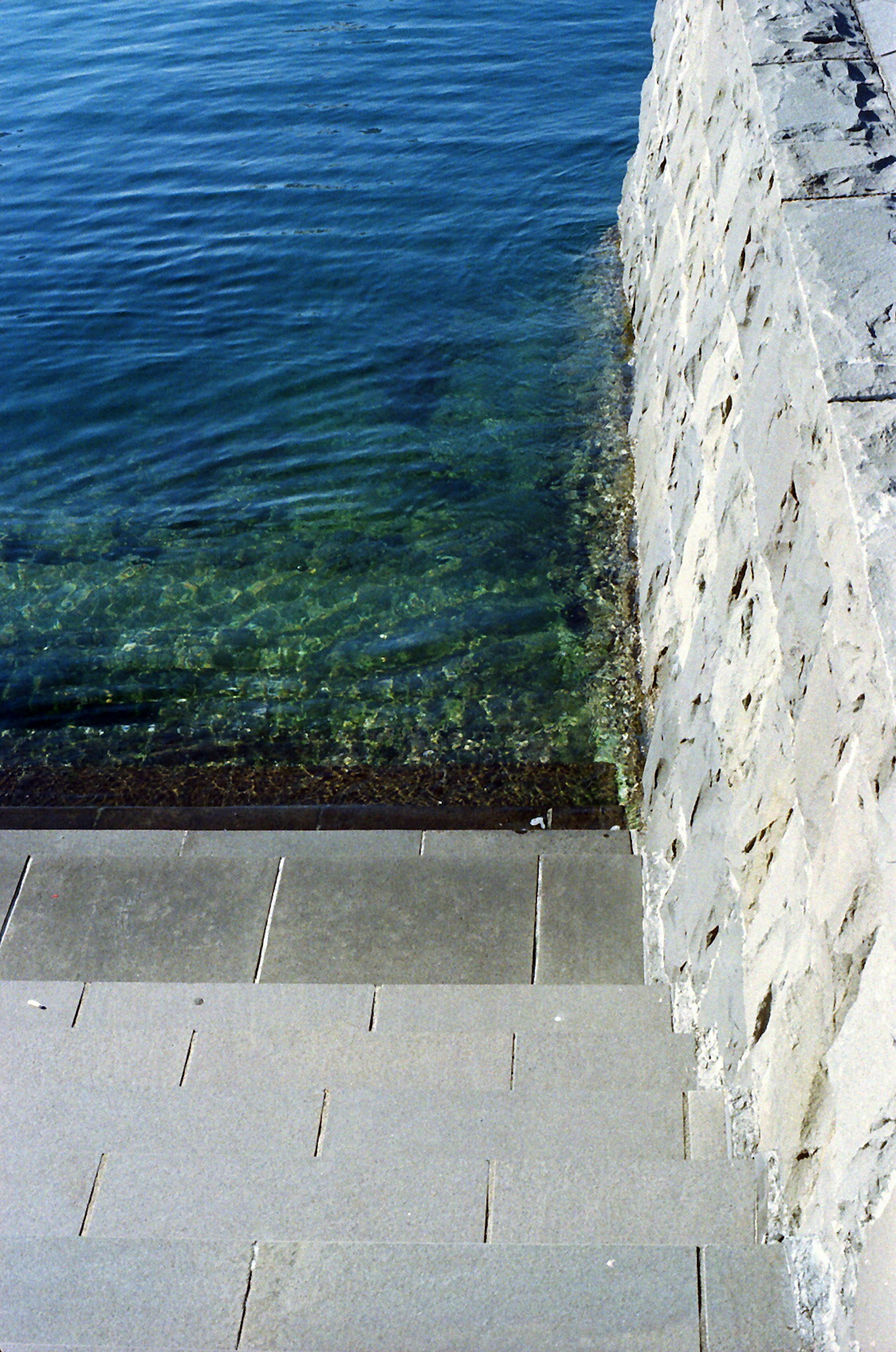 Vue du mur en pierre et des marches menant à l'eau