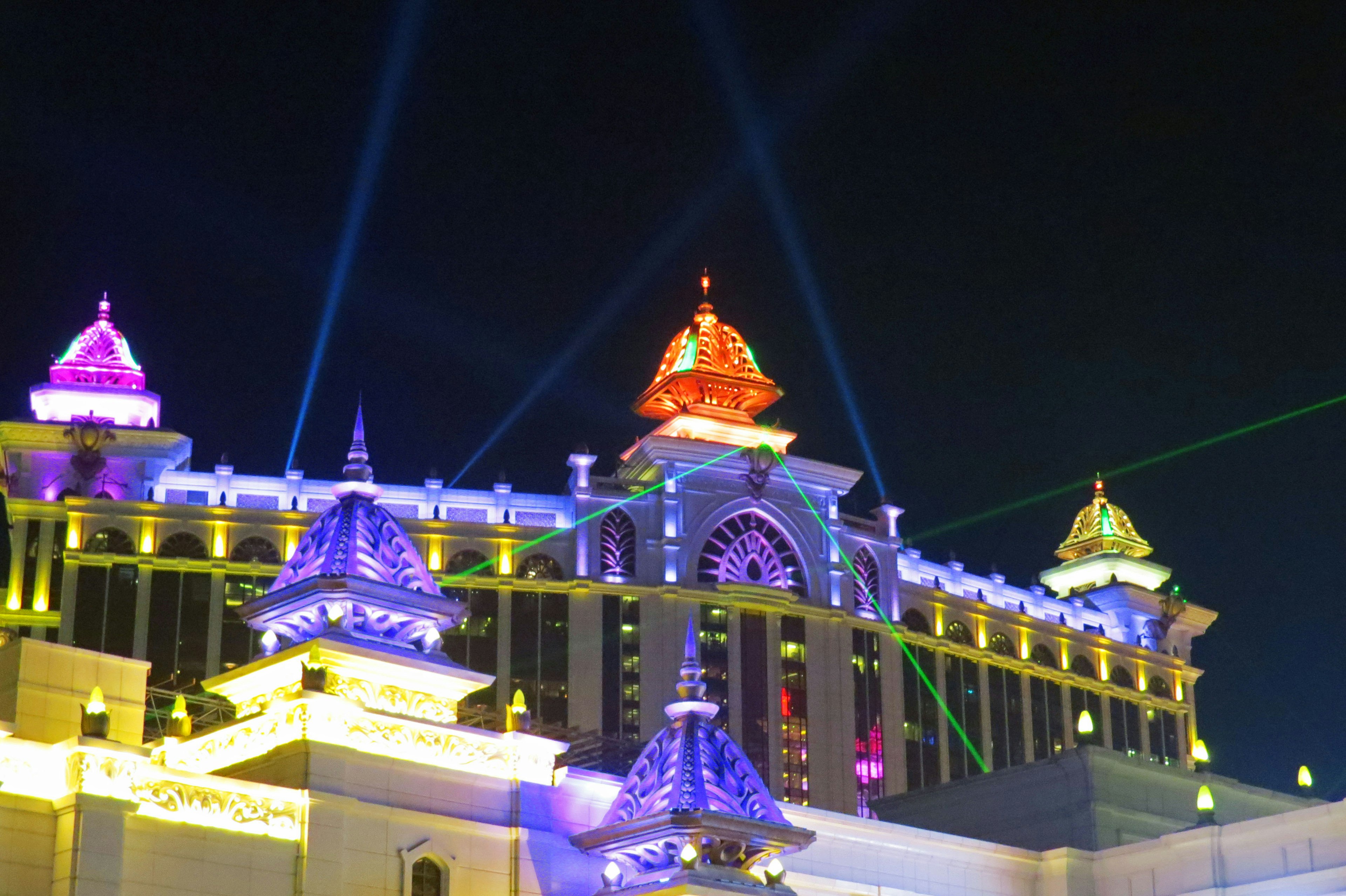 Illuminated luxurious building rooftops with colorful lights at night