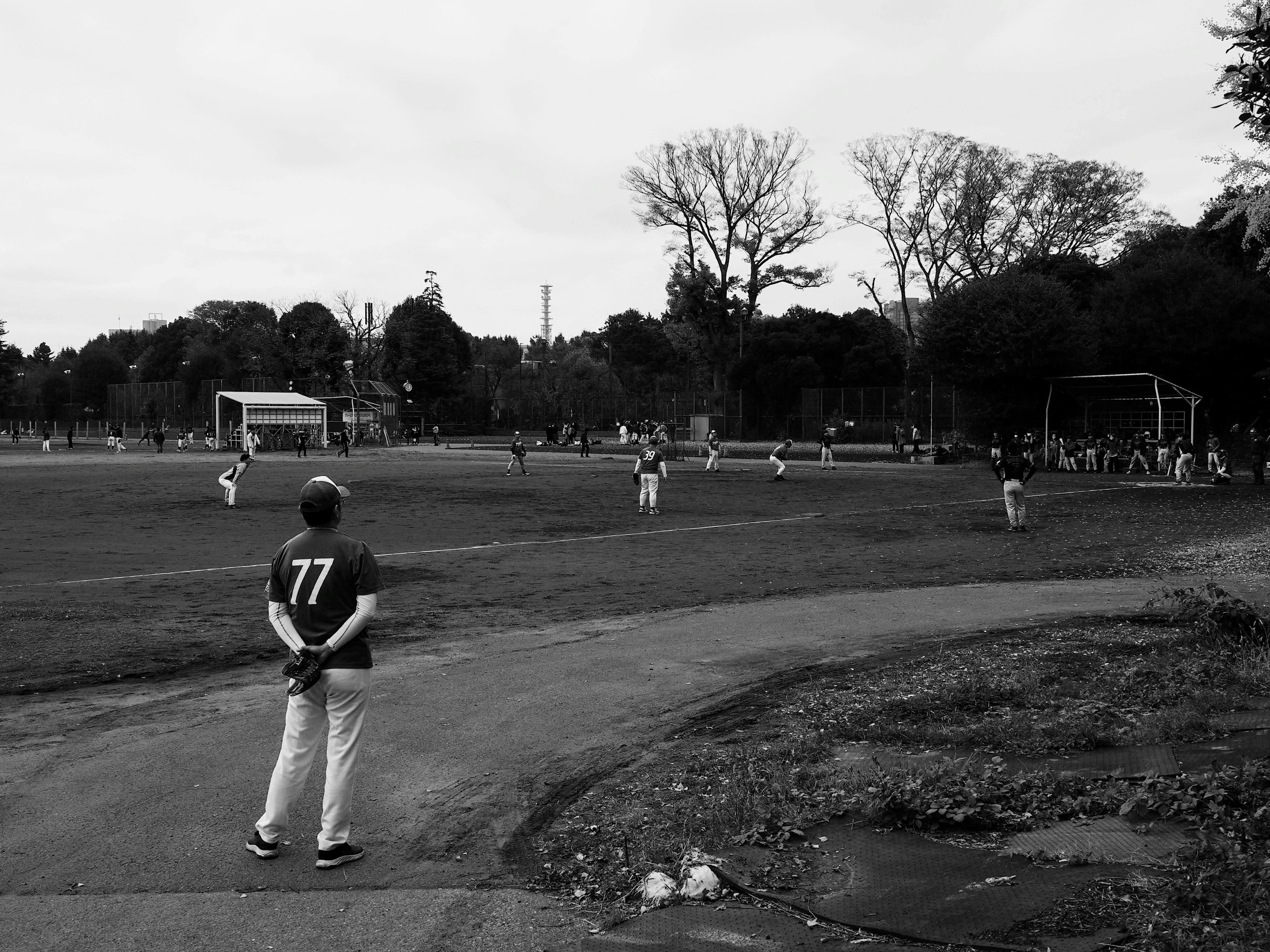 Players on a baseball field with a spectator in the foreground