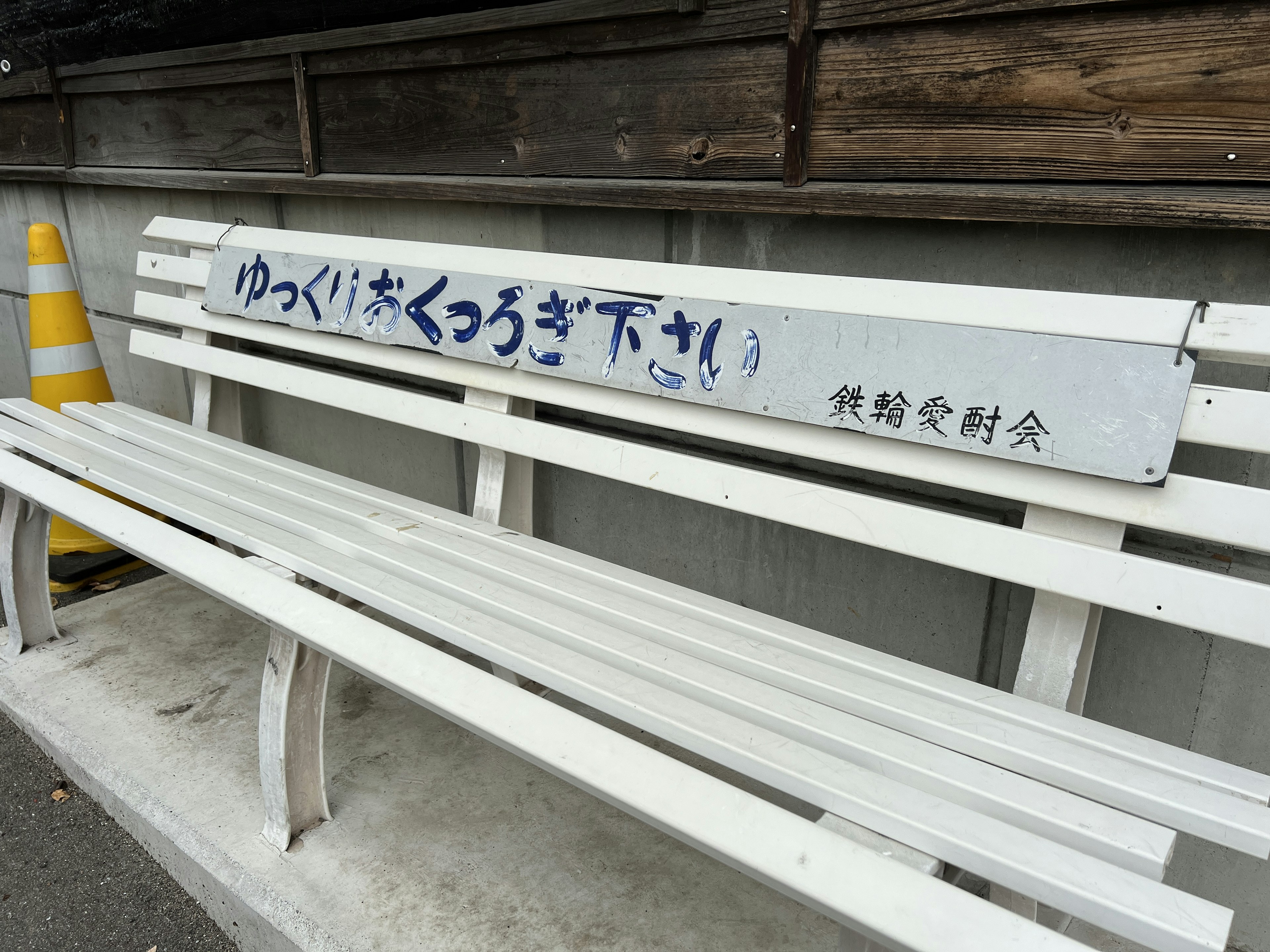 White bench with Japanese text and surrounding environment