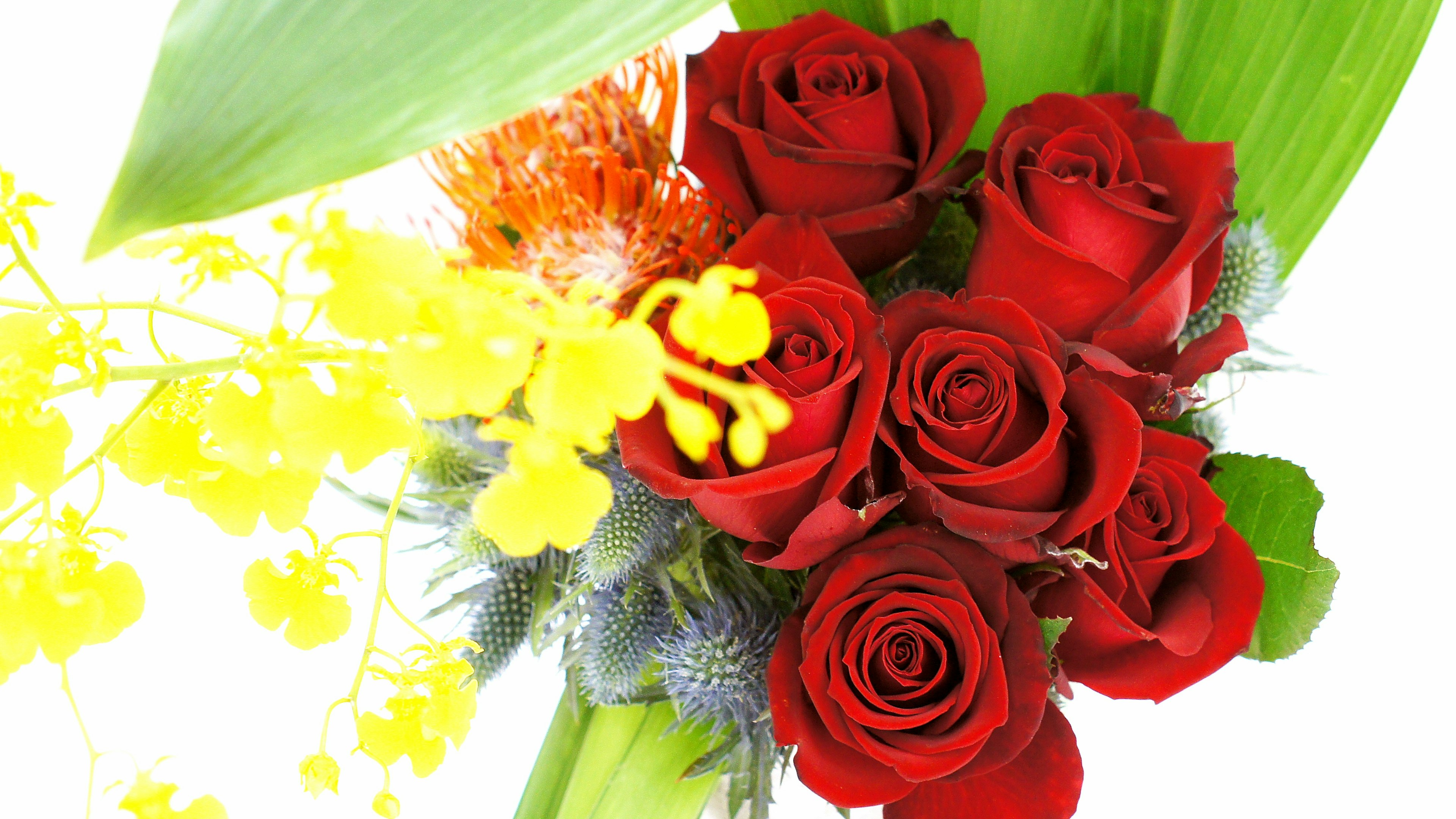 A bouquet of red roses with yellow flowers and green leaves