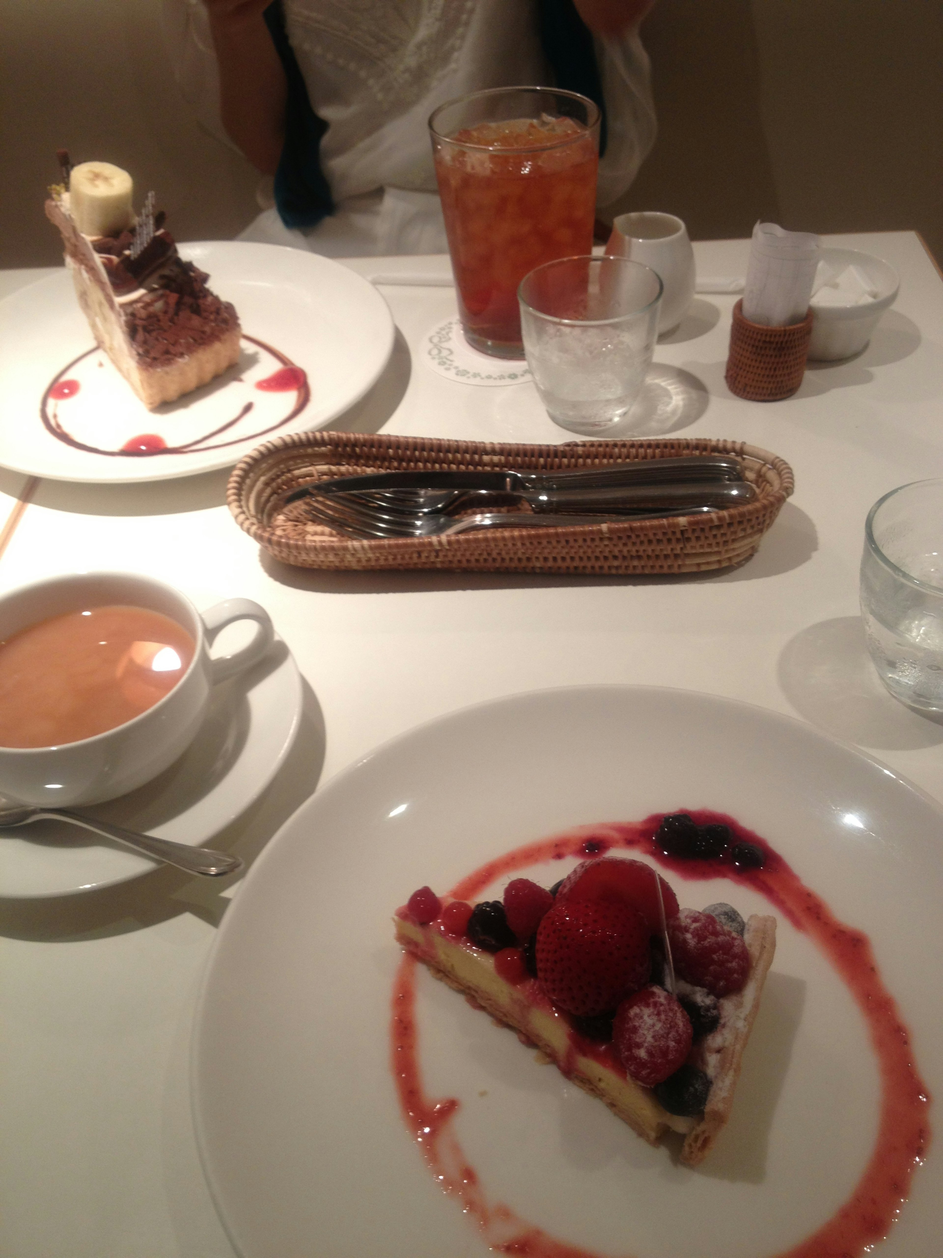 Plato de postre con pastel de bayas y helado junto a café y bebidas