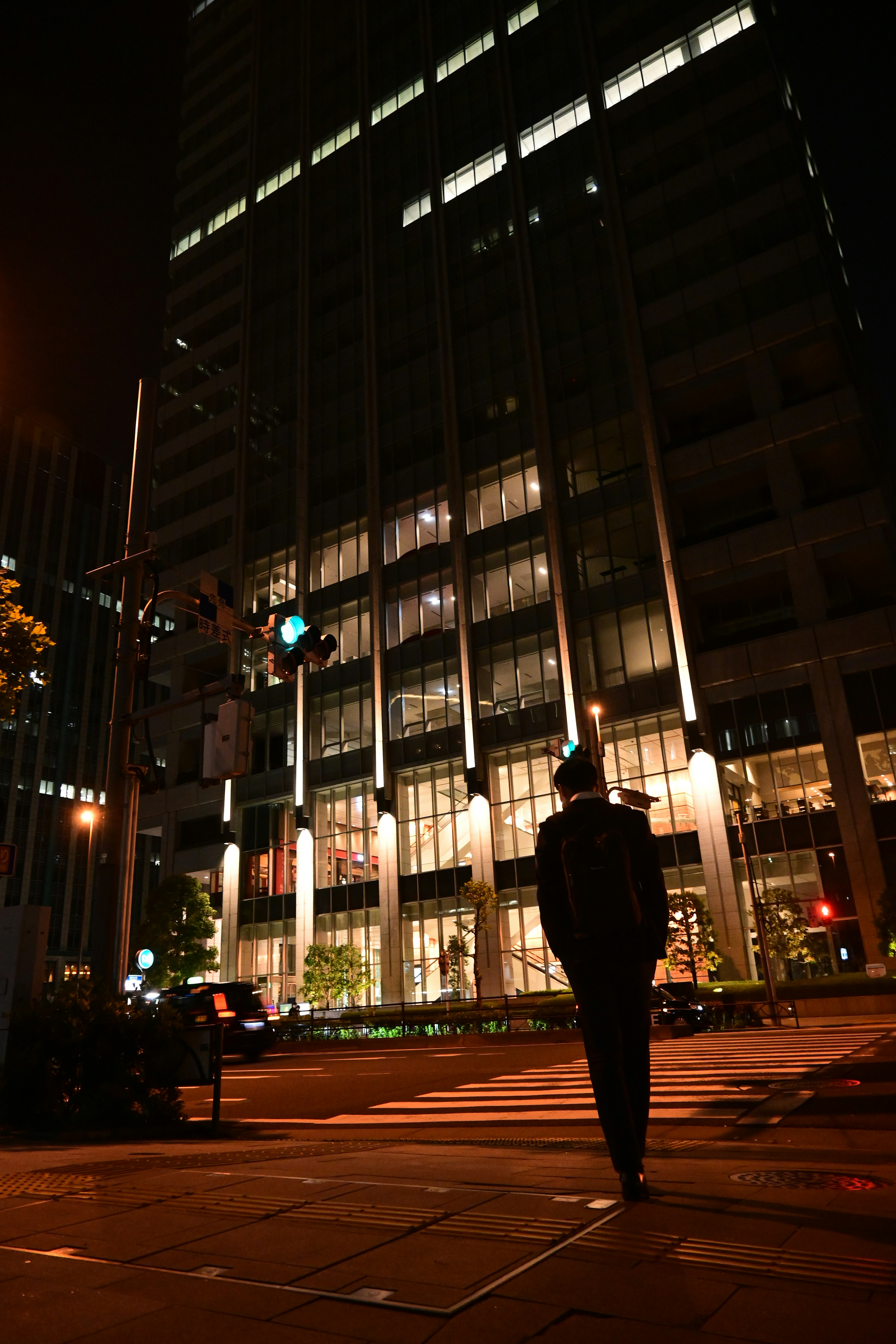 夜の都市景観で歩く人と明るいビル