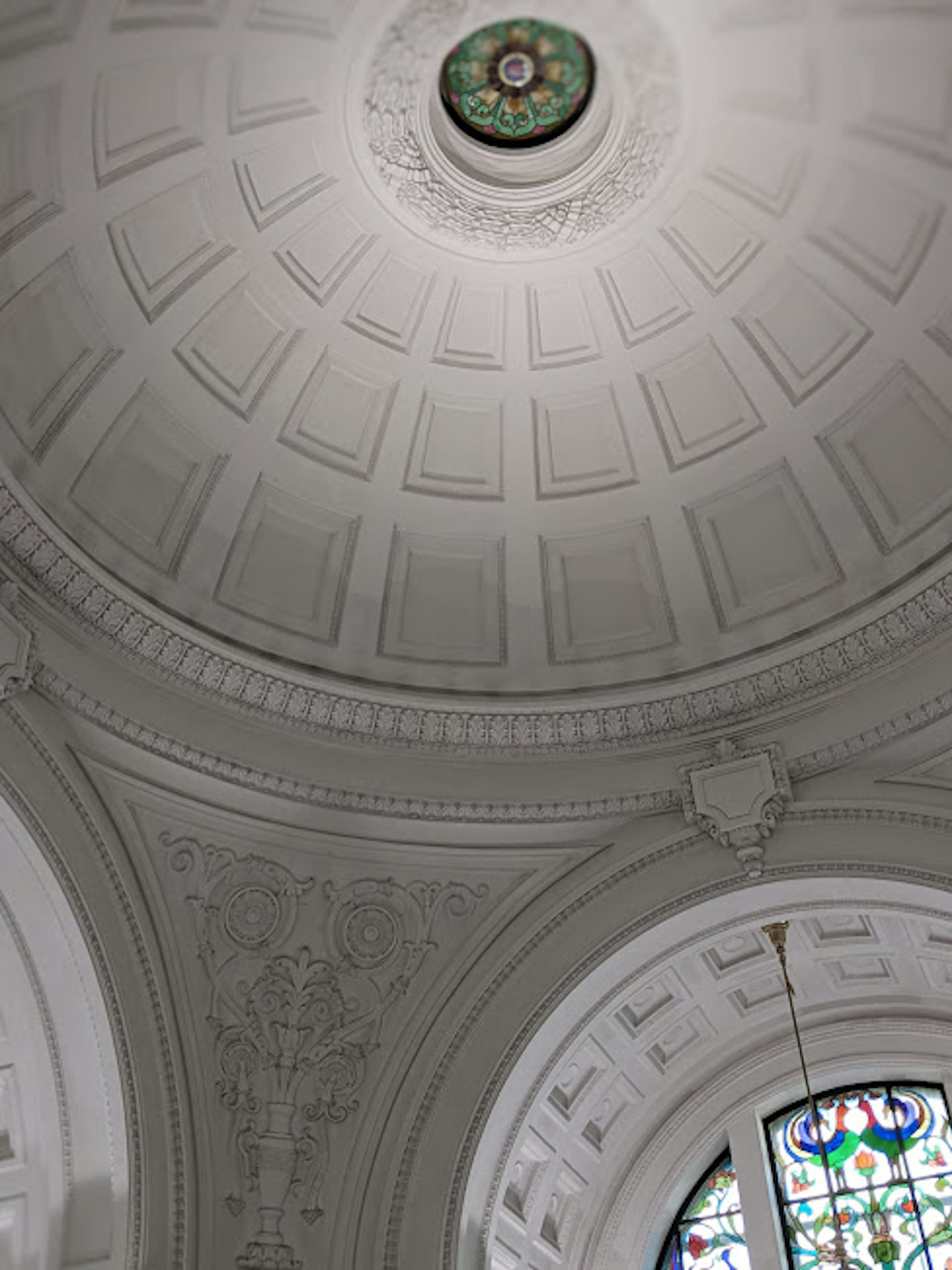 Decorative dome ceiling with intricate patterns and stained glass window