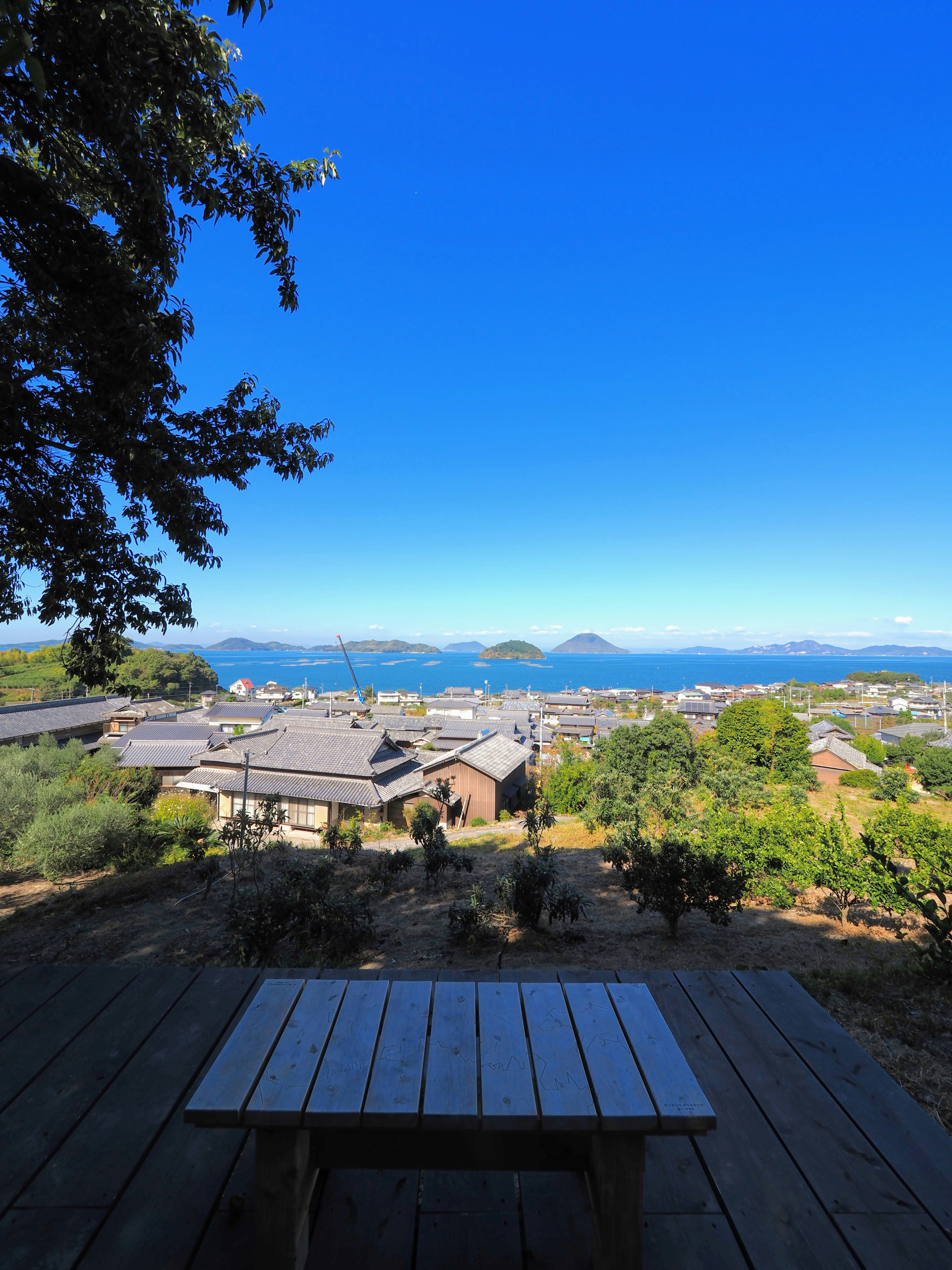 青い空と海の美しい景色を背景にした木製のテーブル