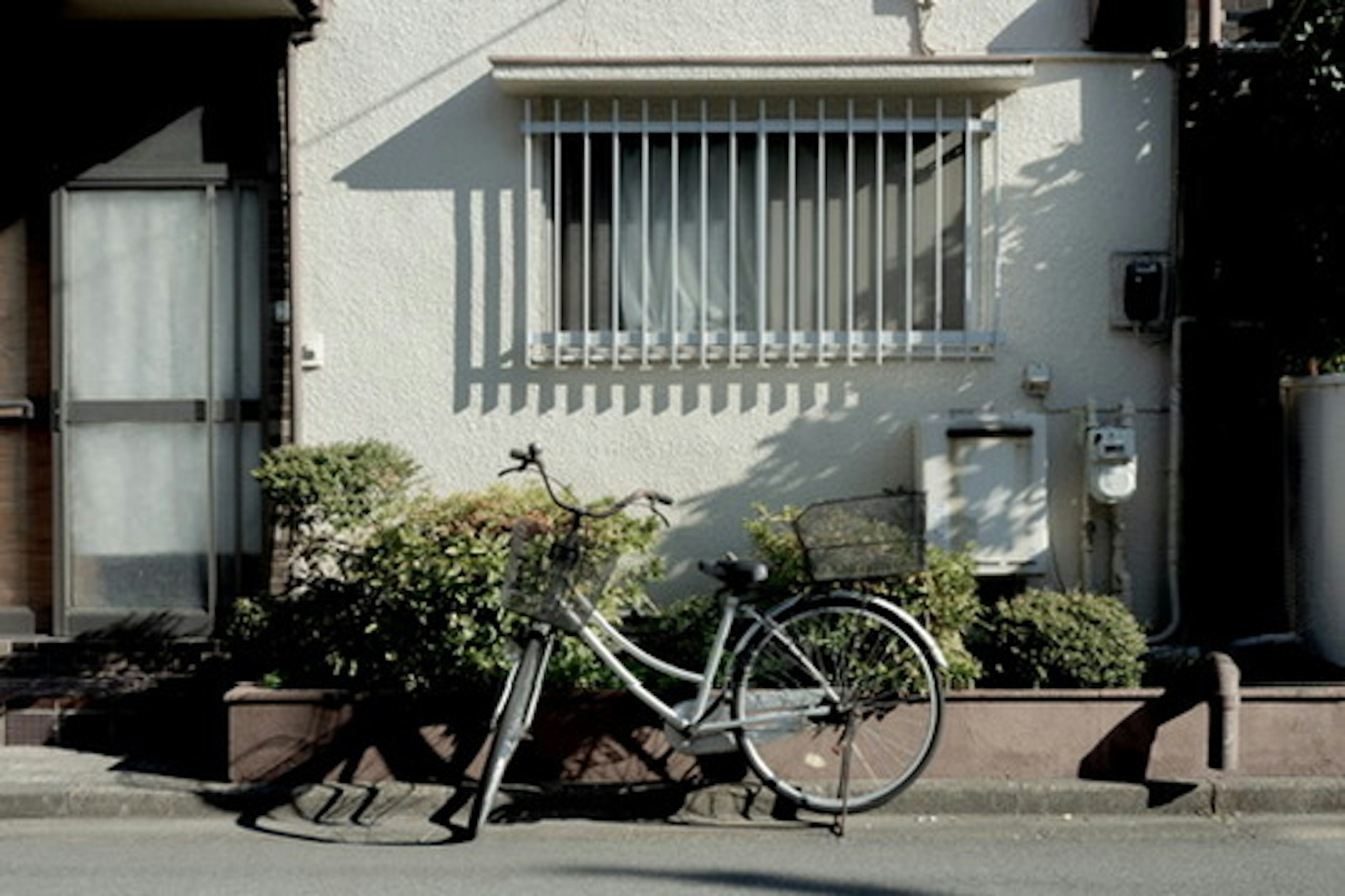 A bicycle leaning against a wall in front of a house