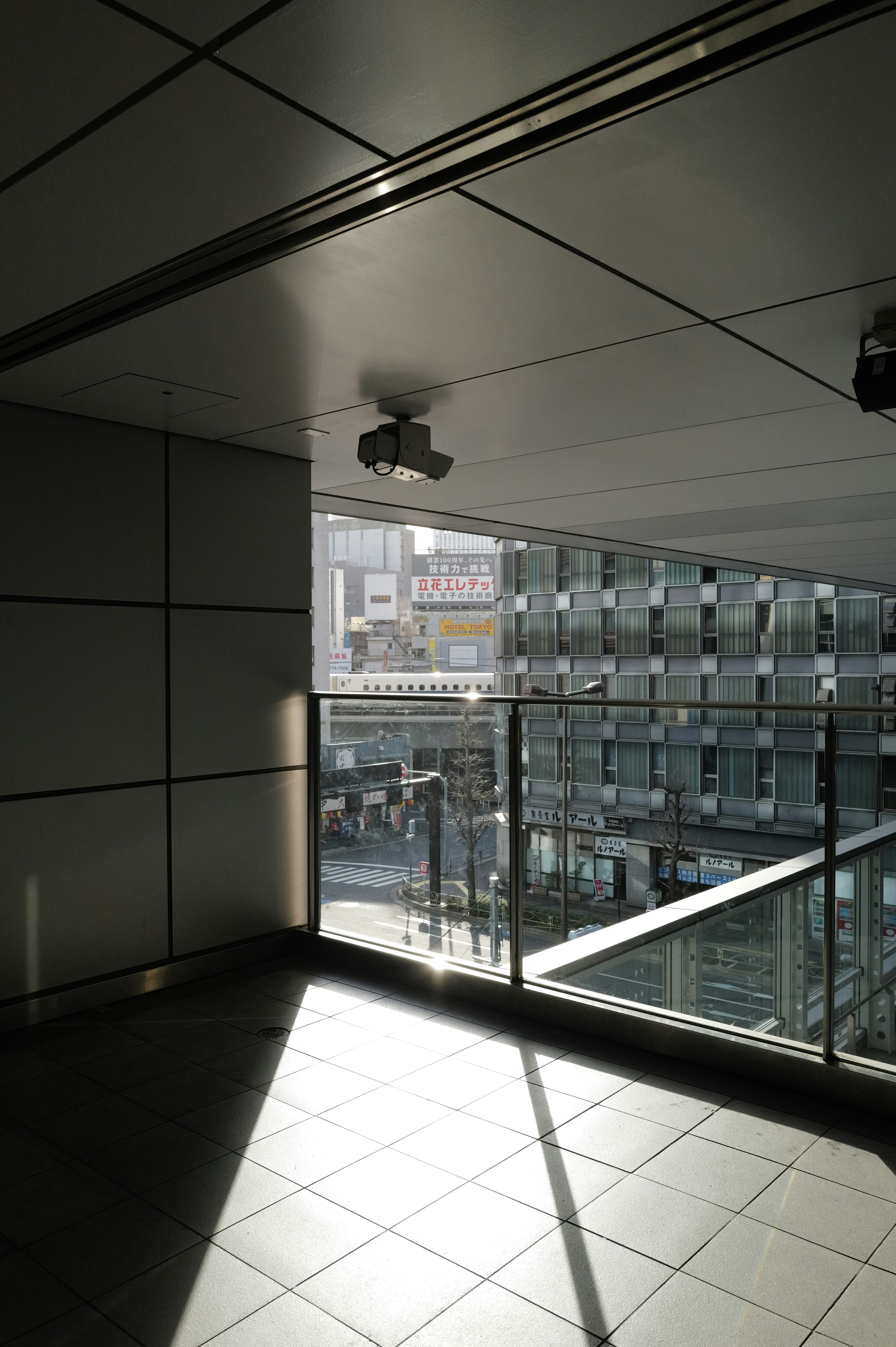 Vue intérieure lumineuse montrant un paysage urbain avec balustrade en verre