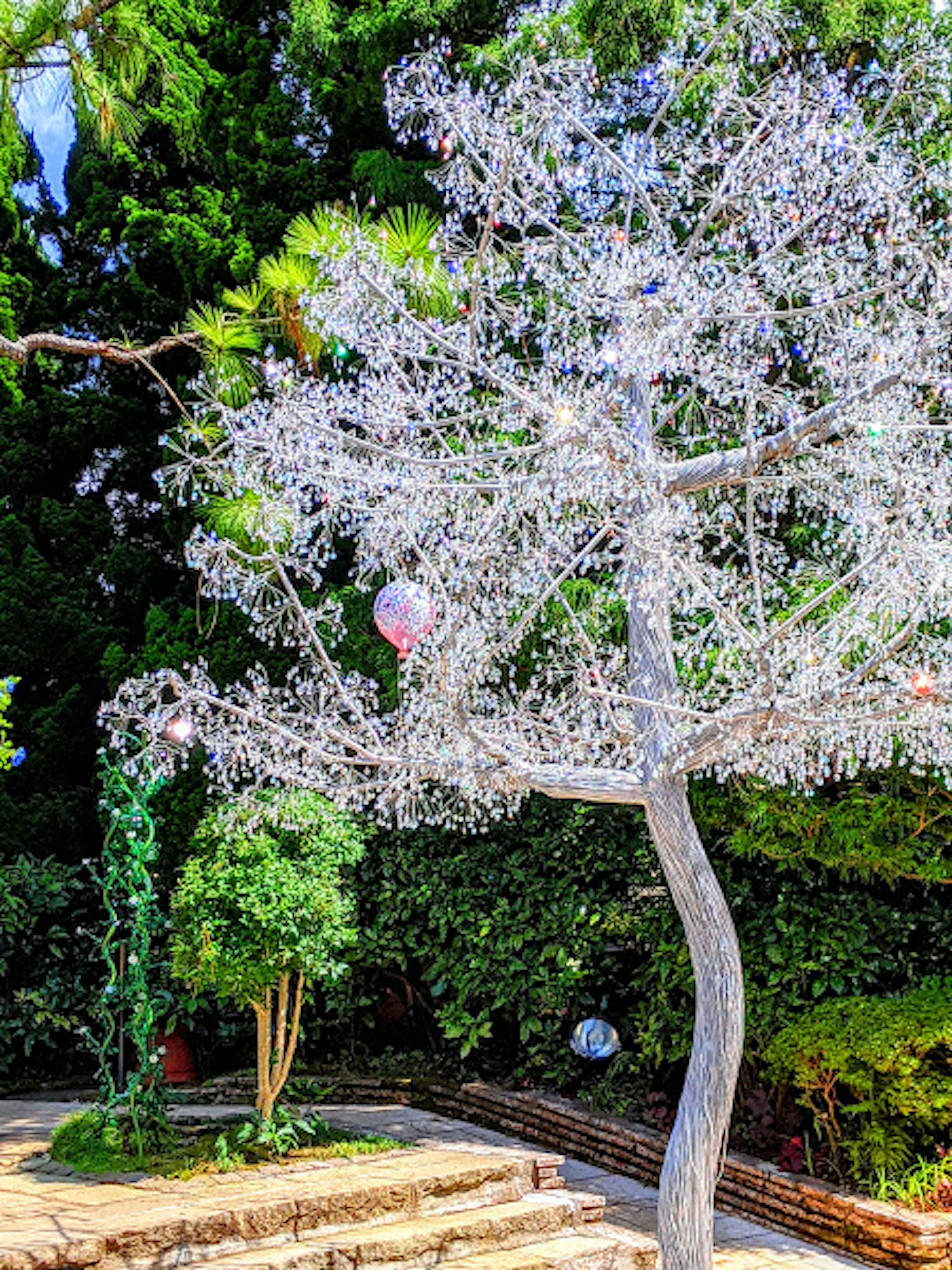 A decorative white tree stands against a green backdrop