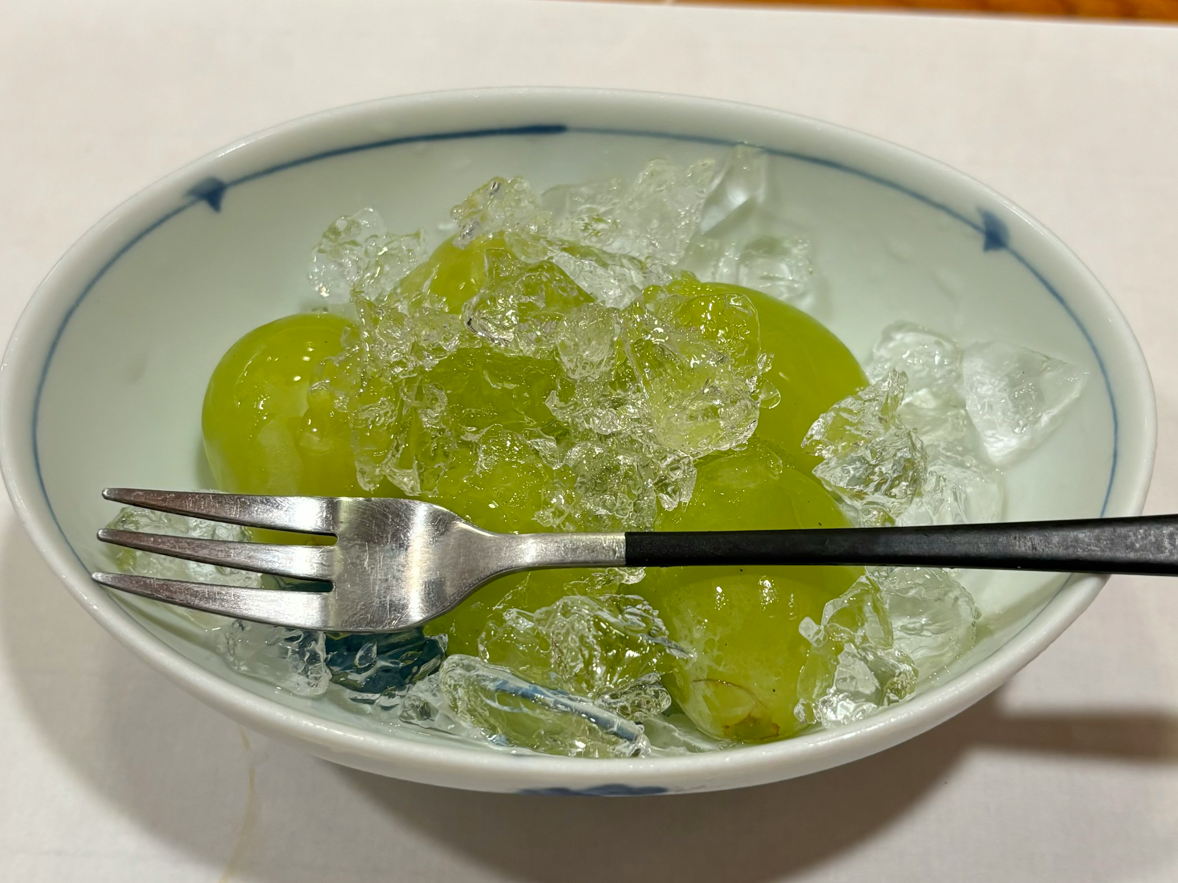 Bol con fruta verde y hielo servido con un tenedor