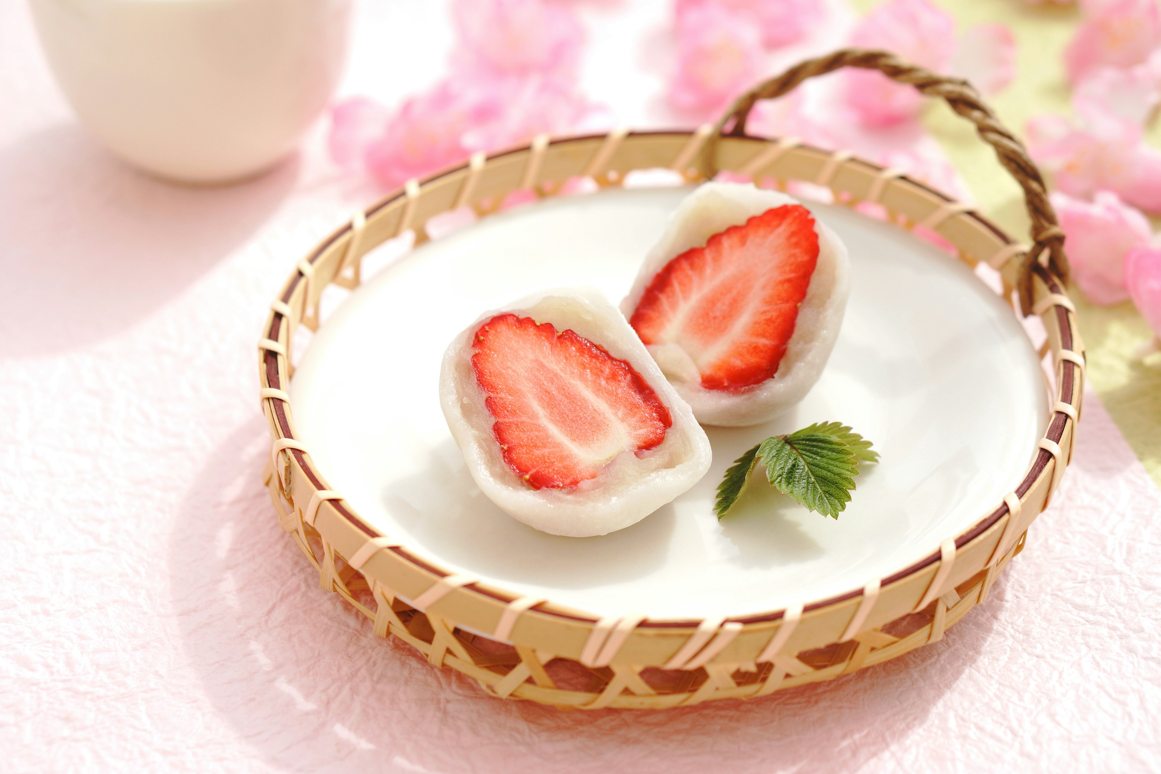 Daifuku aux fraises présenté sur une assiette blanche avec un fond décoratif