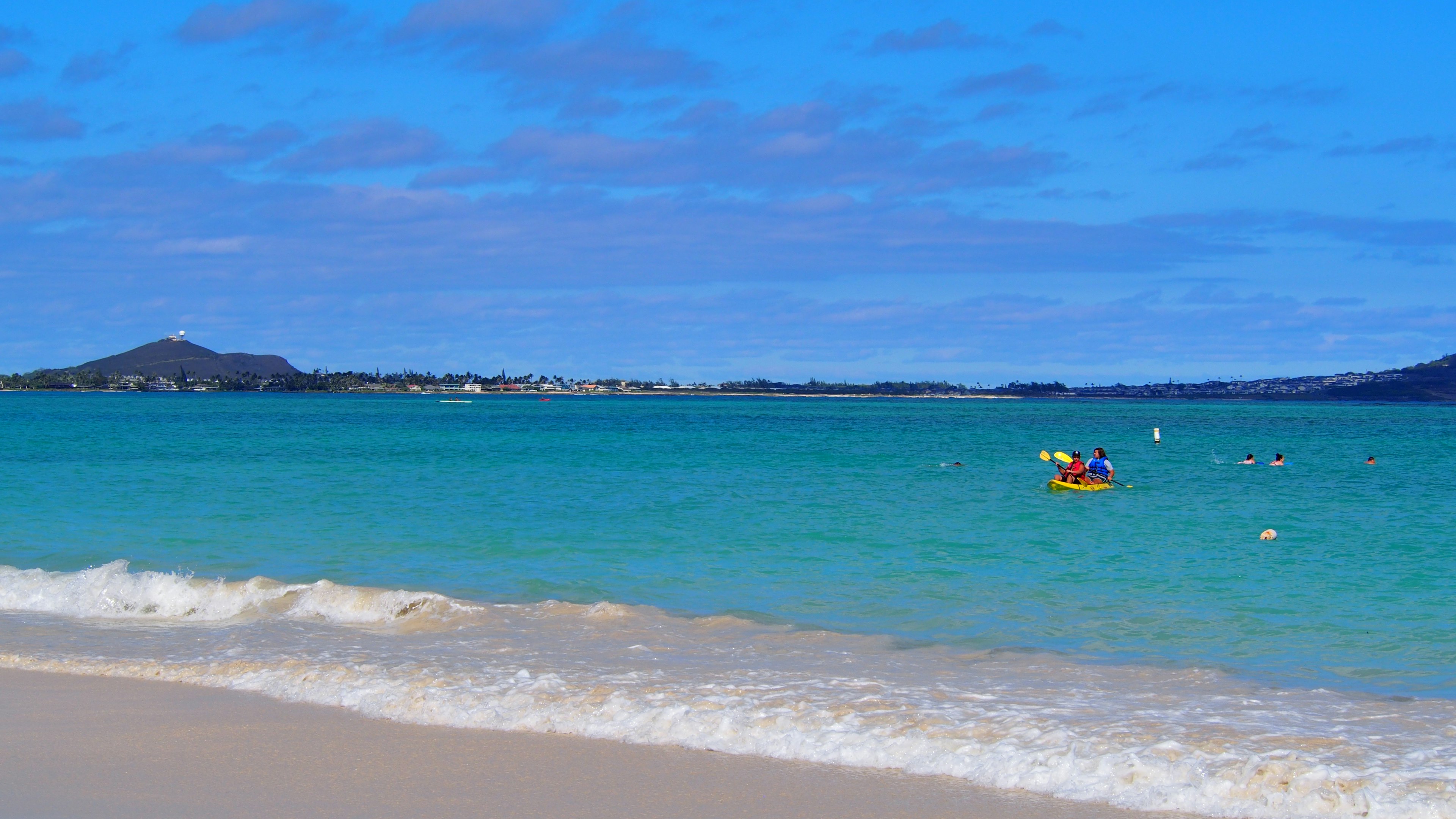 Beautiful beach with turquoise water and people kayaking