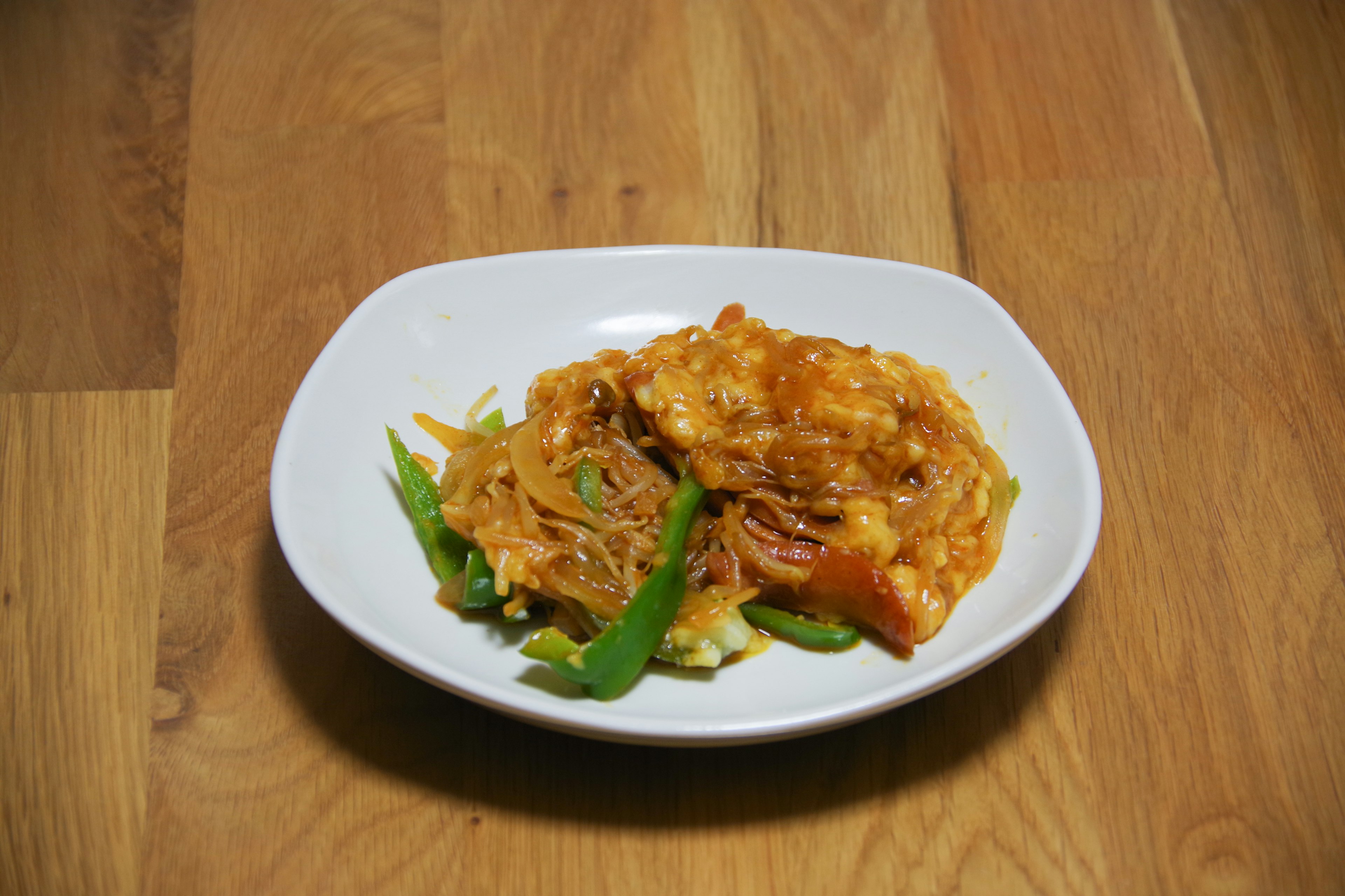 Dish with vegetables and sweet-spicy sauce on a white plate