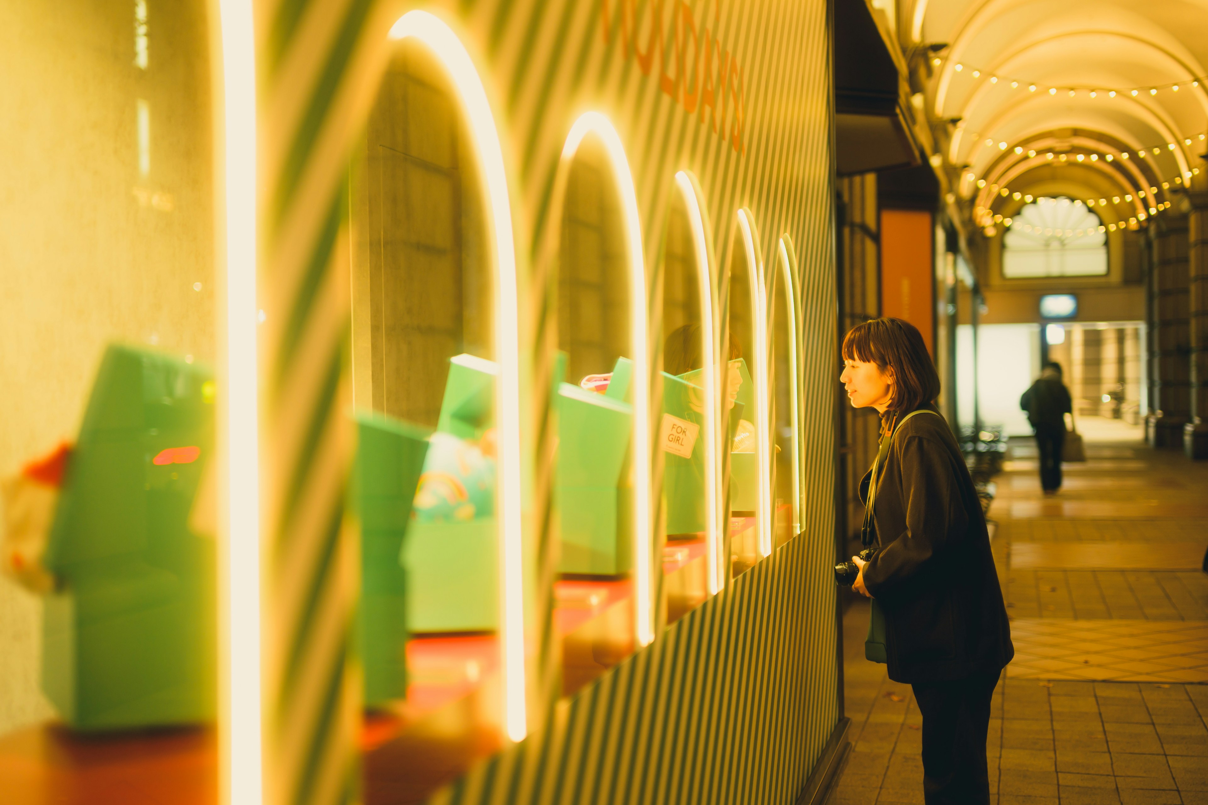 Woman gazing at a store window in an arcade street setting