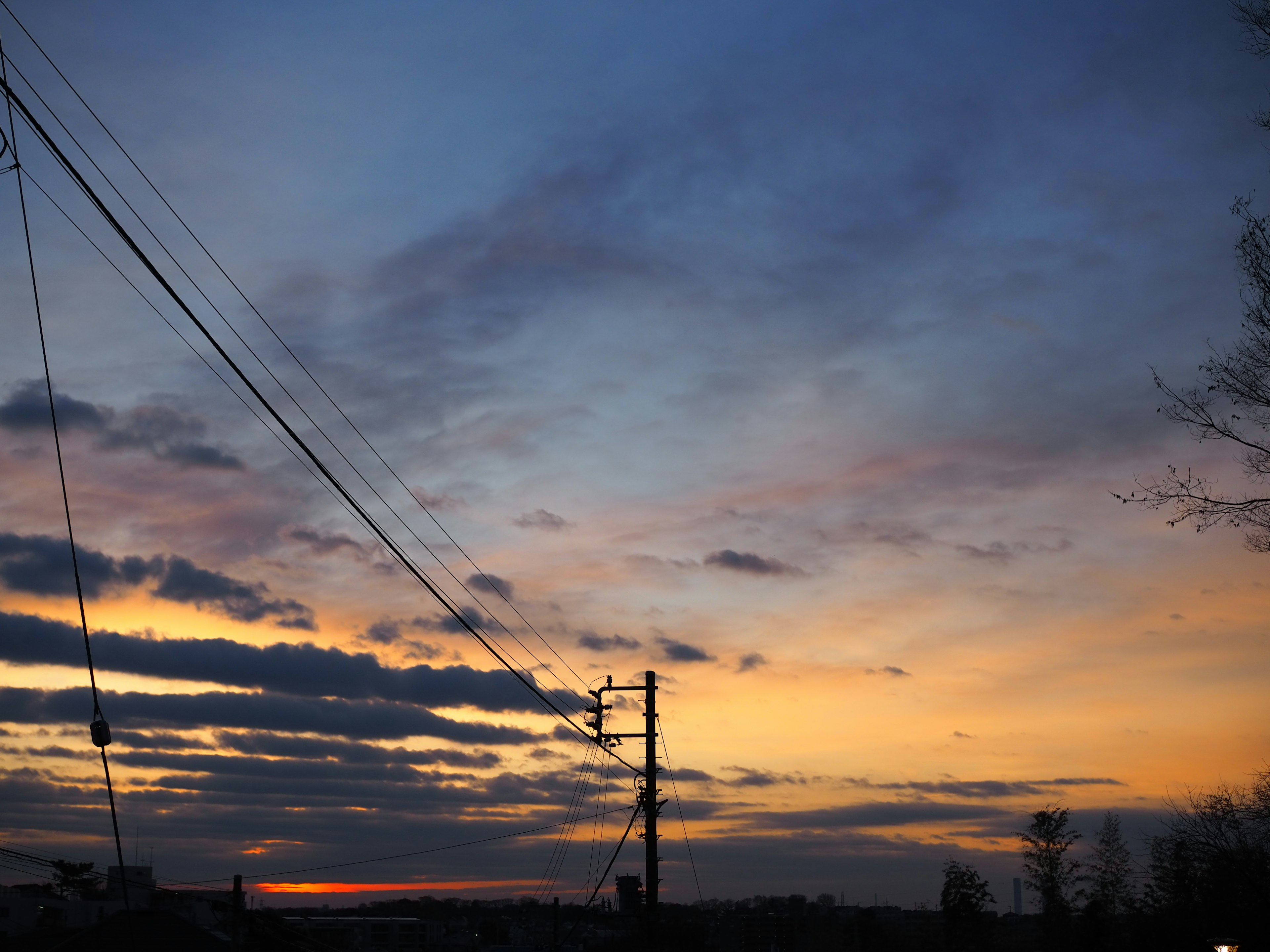 Malersicher Sonnenuntergang mit bunten Wolken und Strommasten