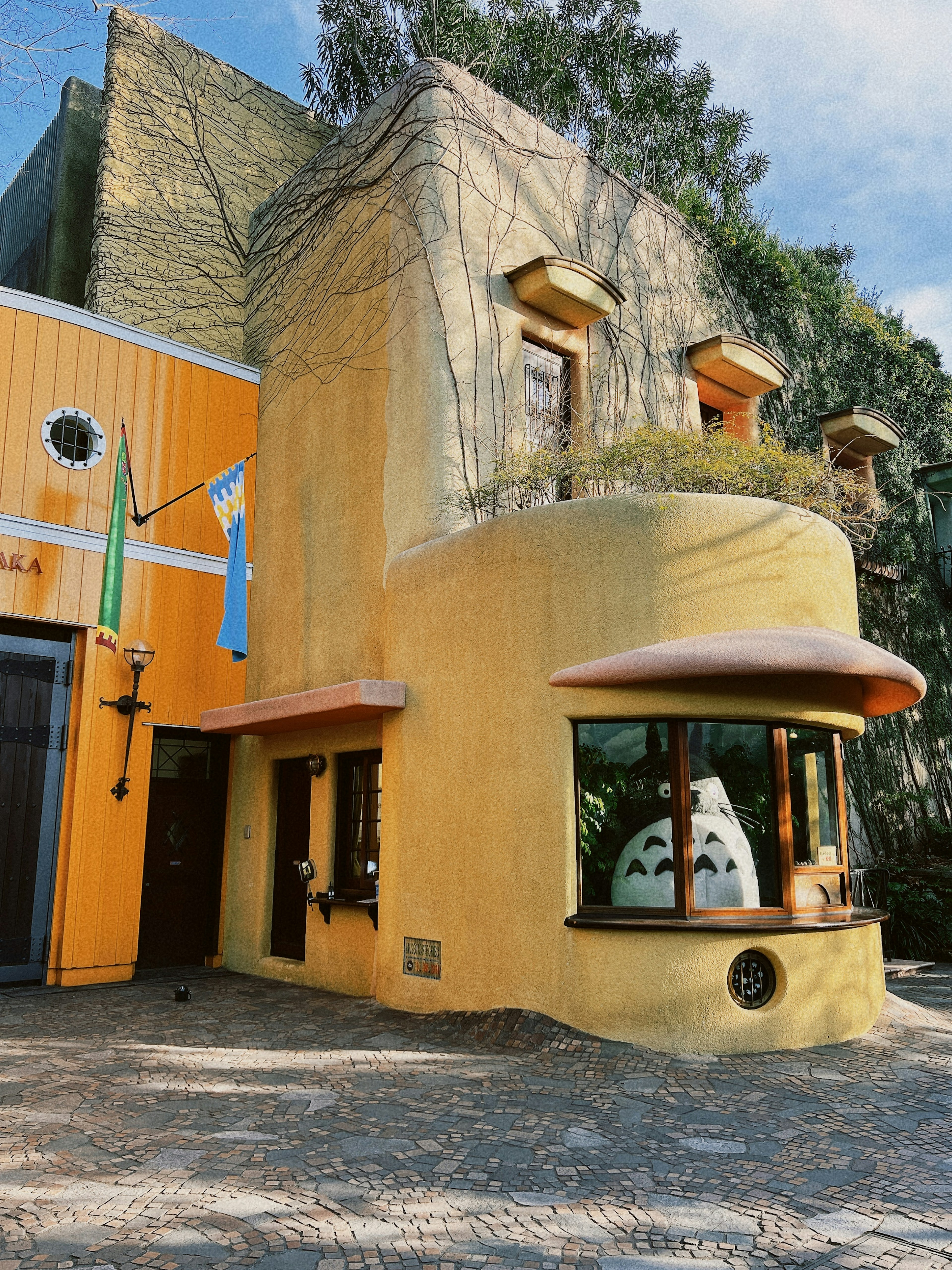 Unique yellow building exterior with large windows and a rounded roof