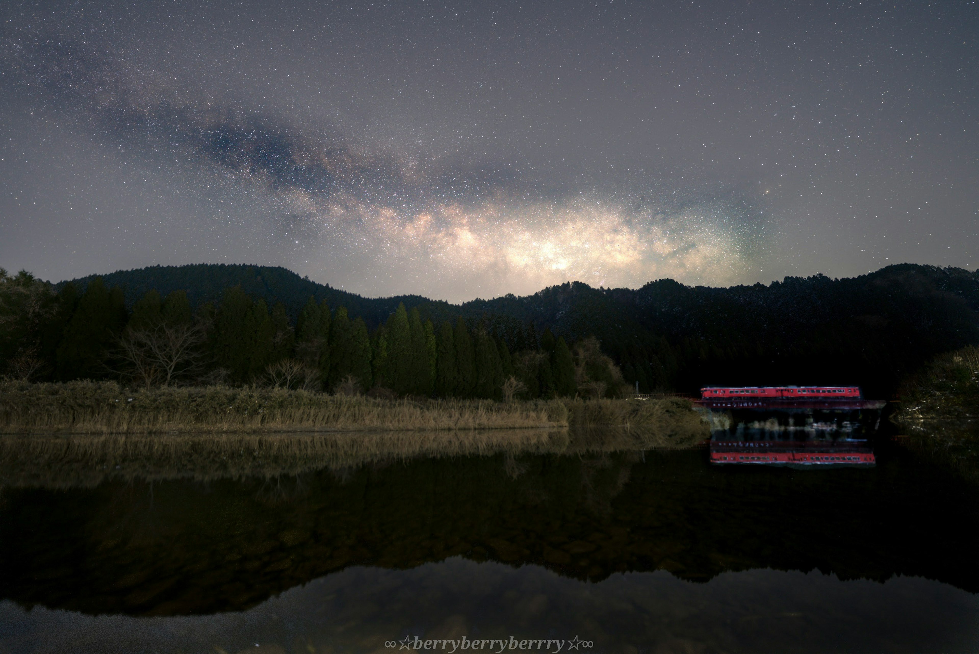 Danau tenang yang memantulkan langit berbintang yang indah dan pegunungan