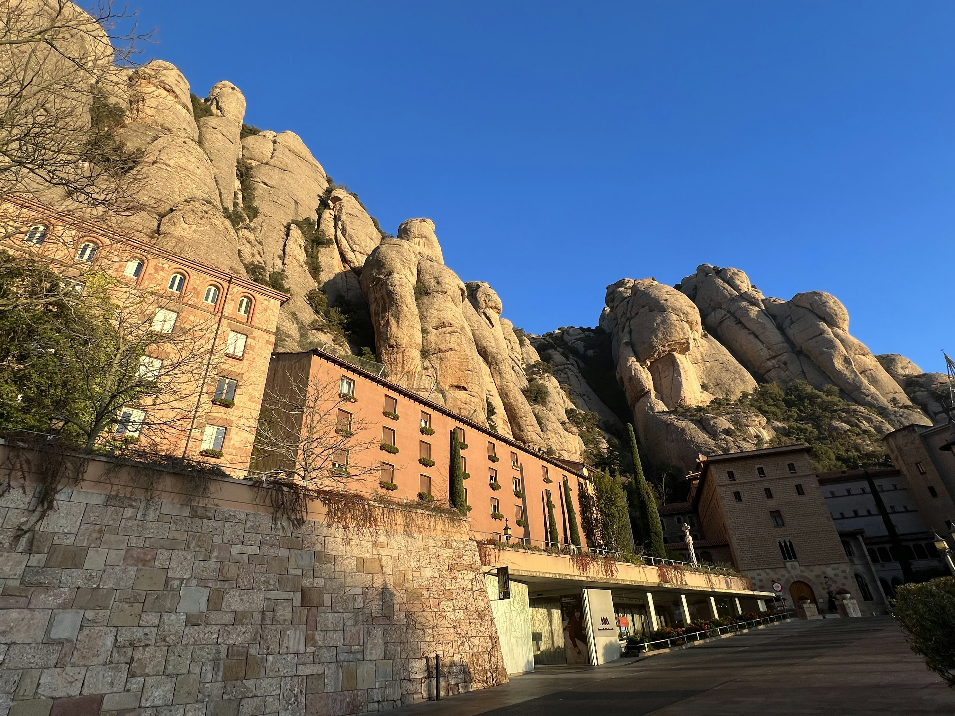 Landscape of Montserrat mountains and monastery with majestic rock formations against a blue sky