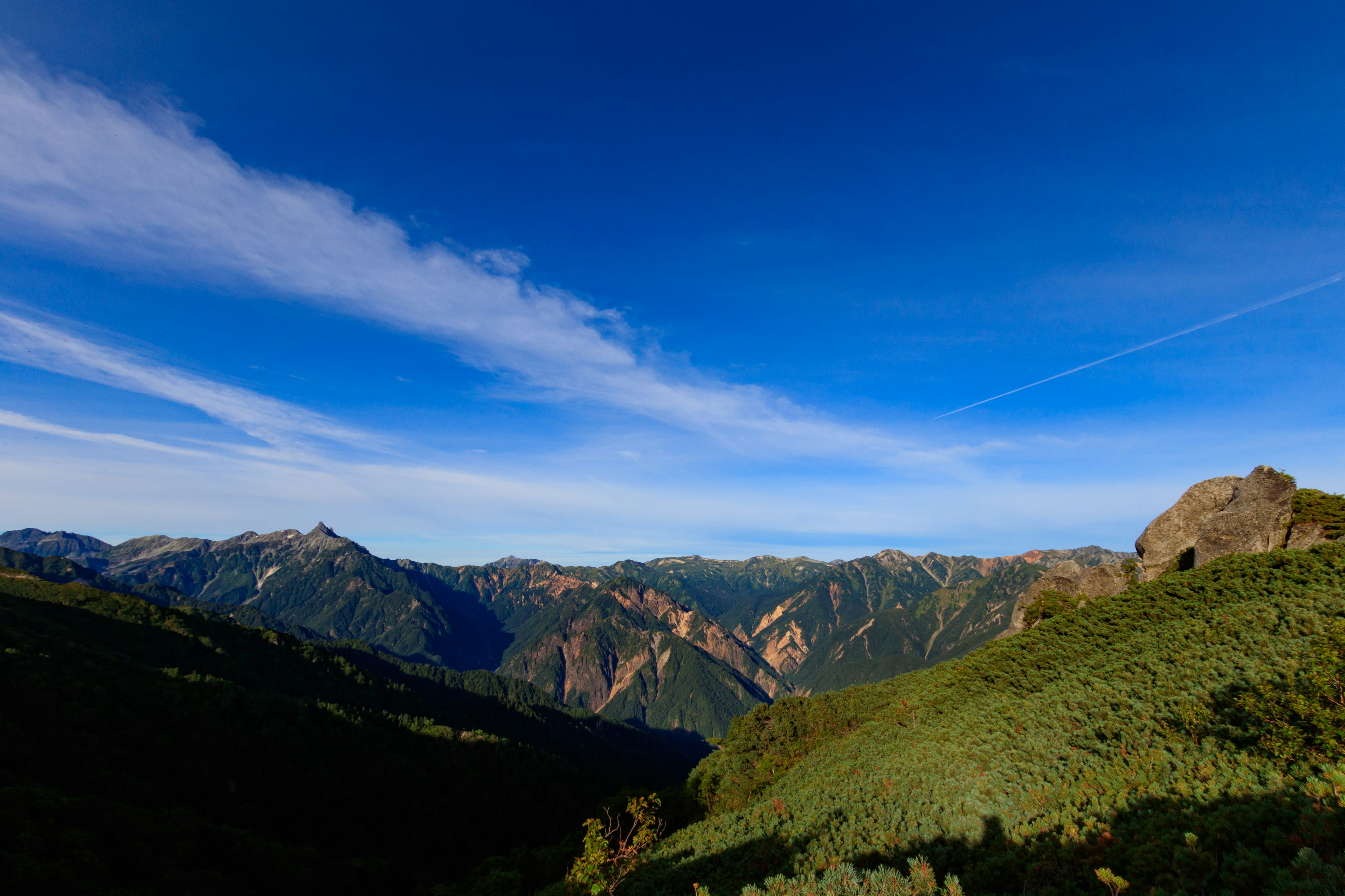 Vue panoramique des montagnes et des collines vertes sous un ciel bleu