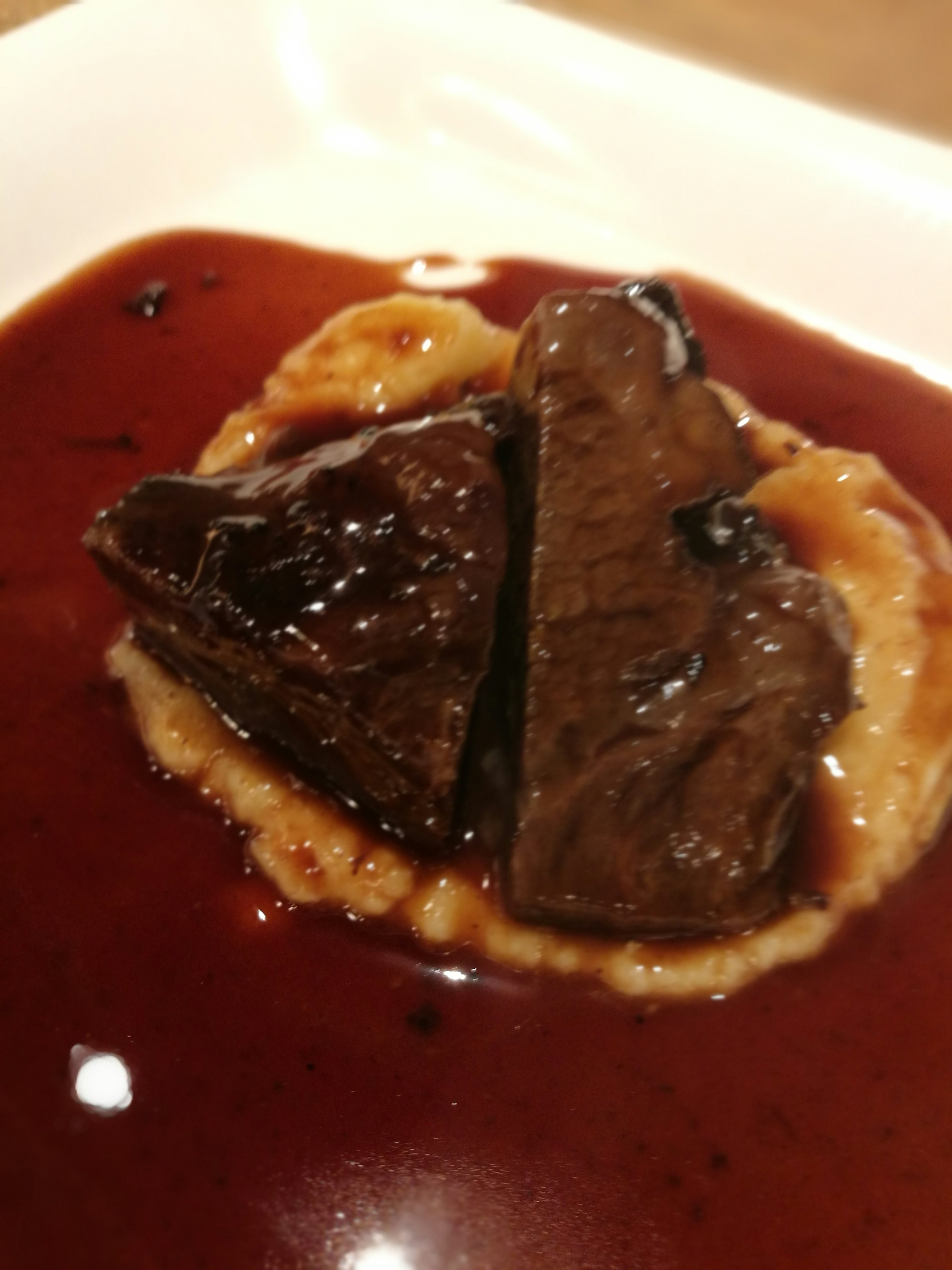 Tender pieces of meat served on a creamy base with a rich red wine sauce