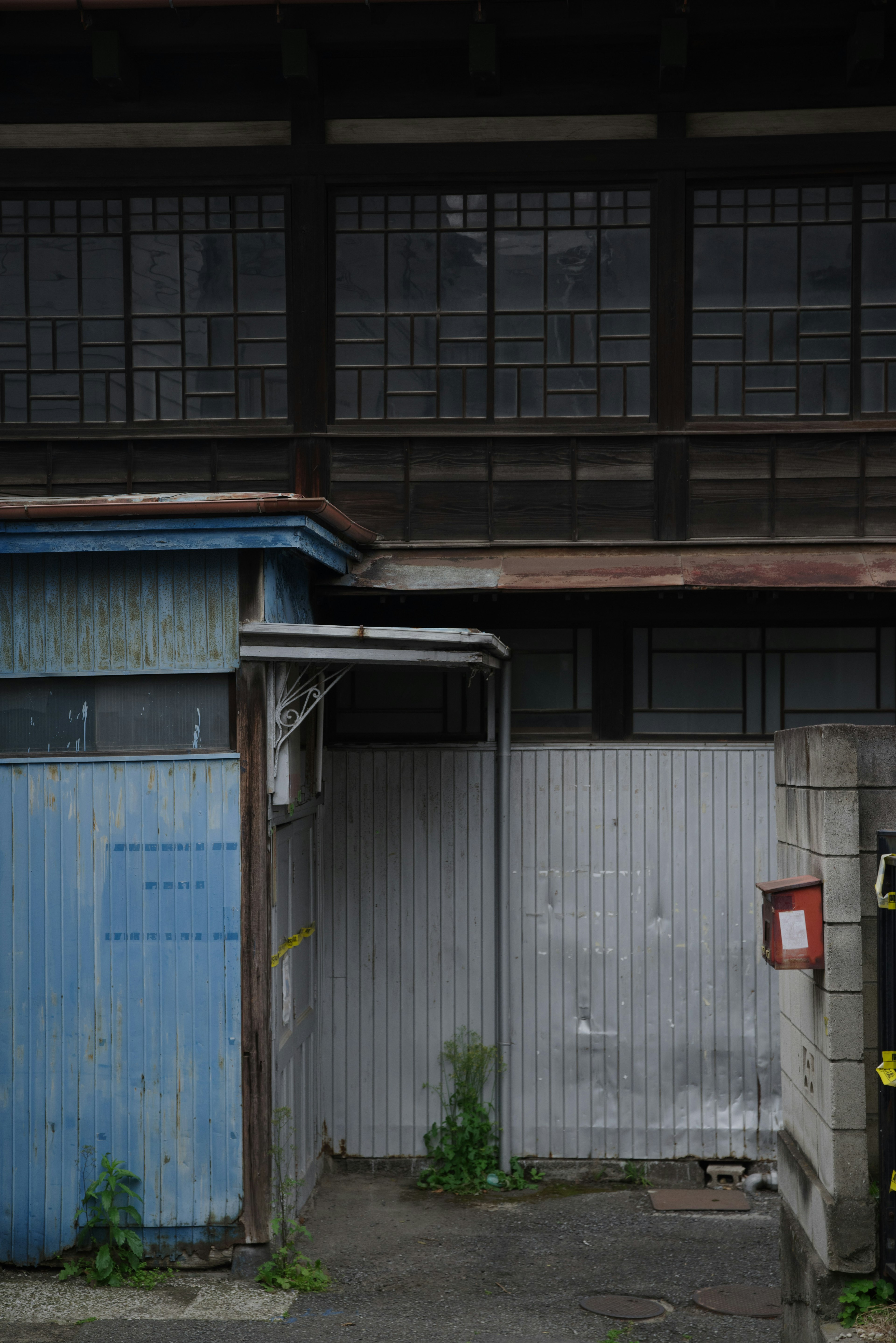 Gambar eksterior bangunan tua dengan dinding biru dan pintu logam