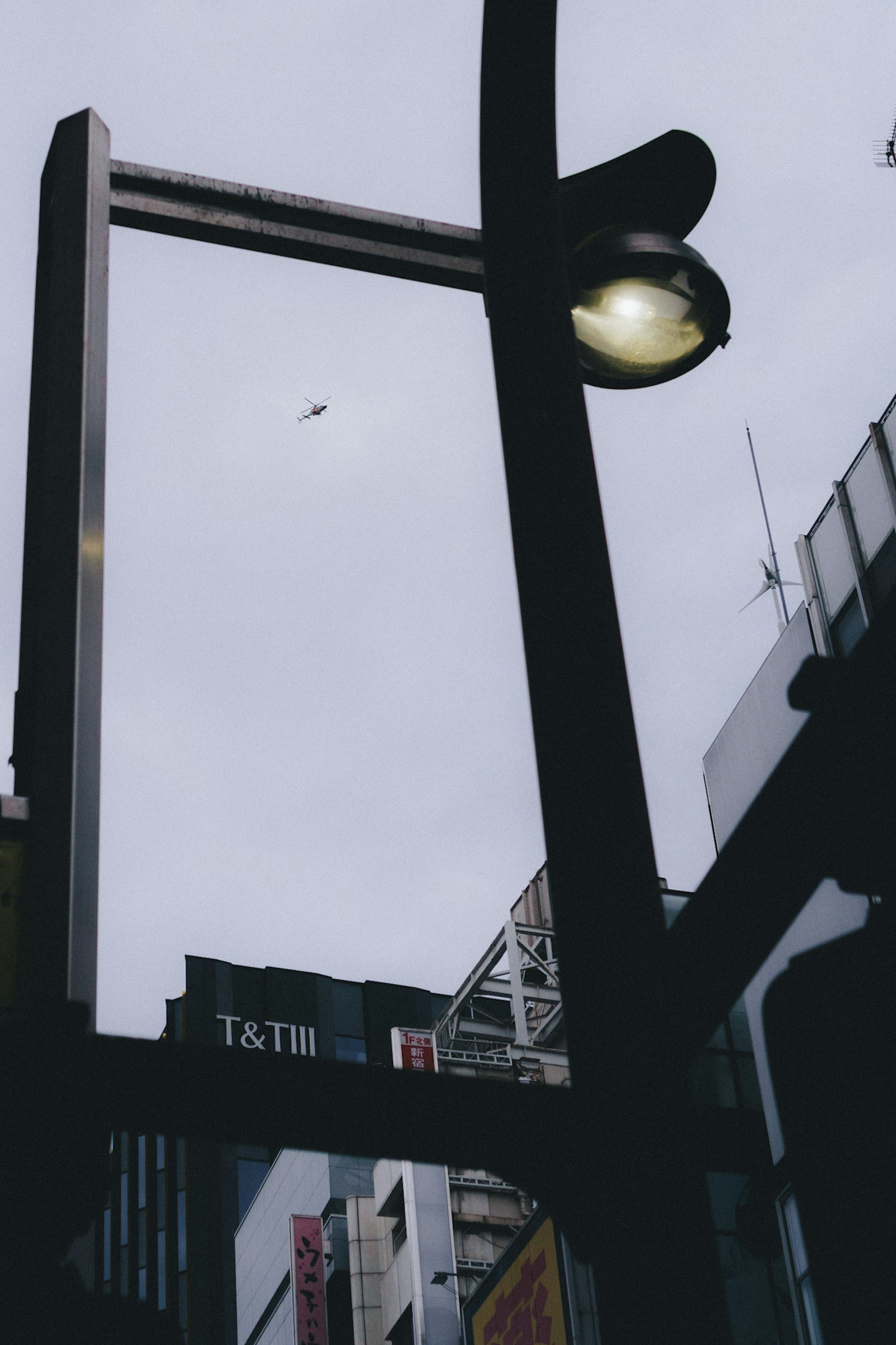 Urban scene featuring a streetlight and part of a building under a cloudy sky