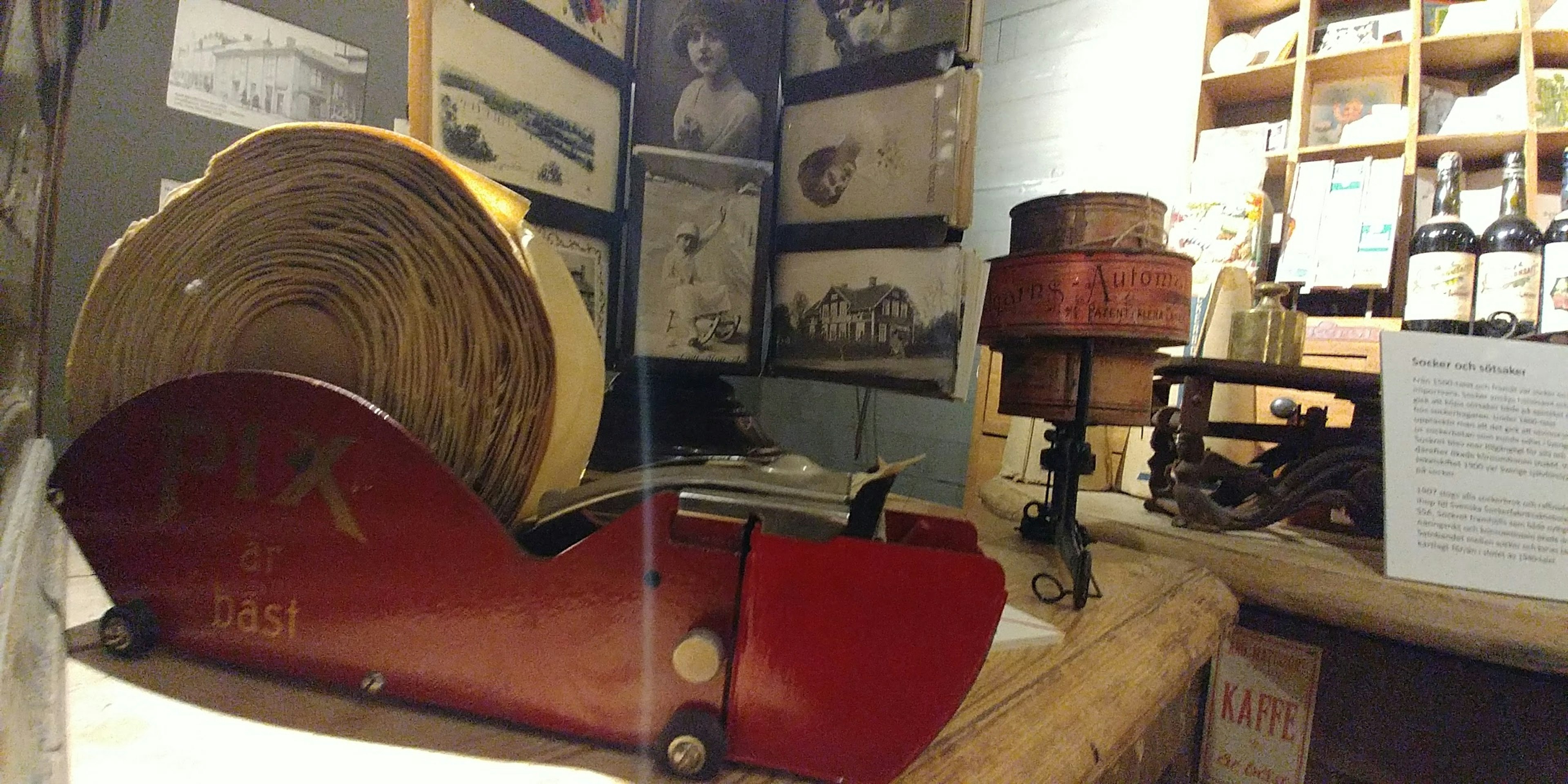 Vintage red machine with wooden scroll displayed in a museum interior