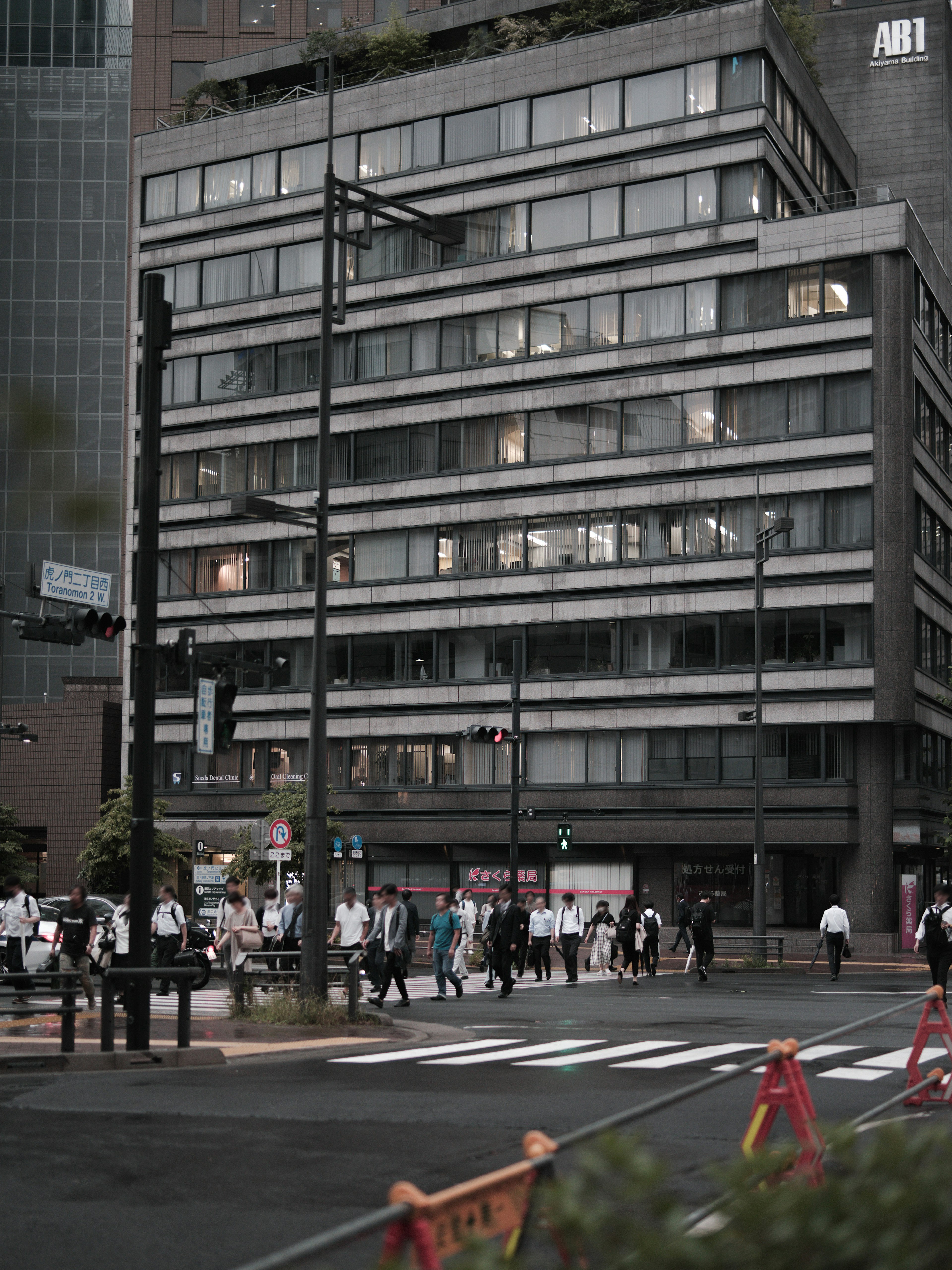 Pedestrians crossing at an urban intersection with a modern building