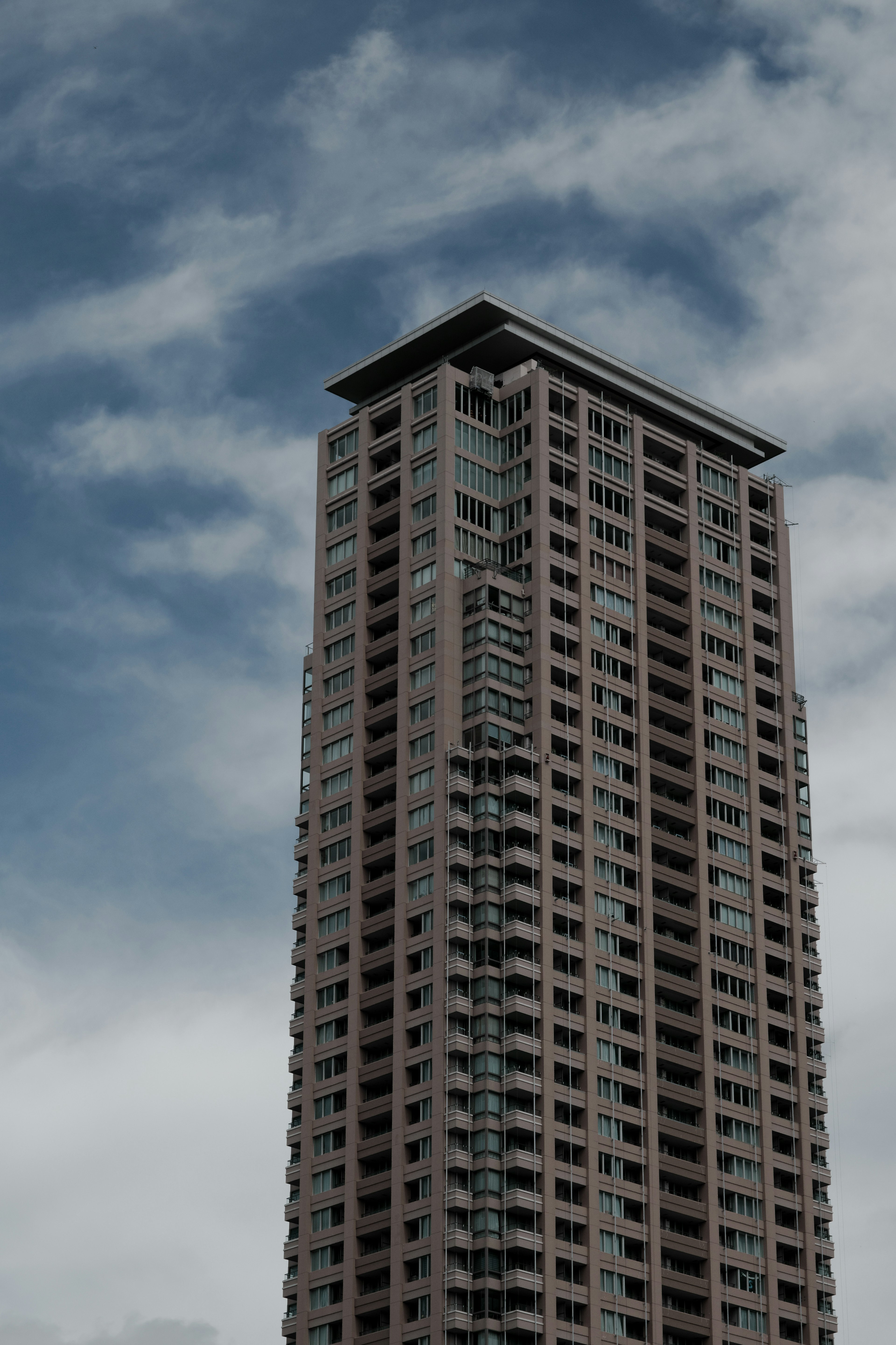 Alto edificio con un design elegante sotto un cielo nuvoloso