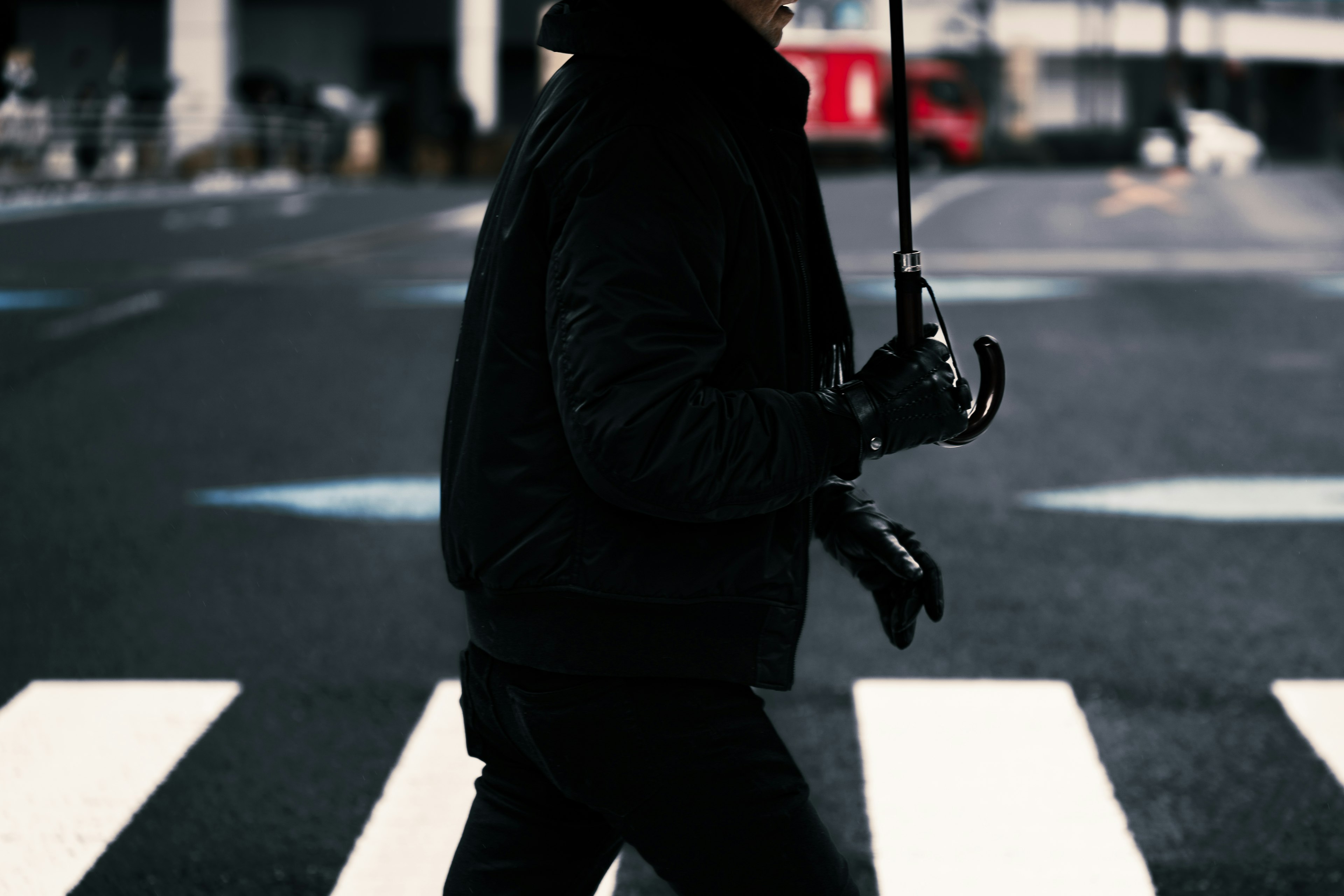 手持雨傘過馬路的人影