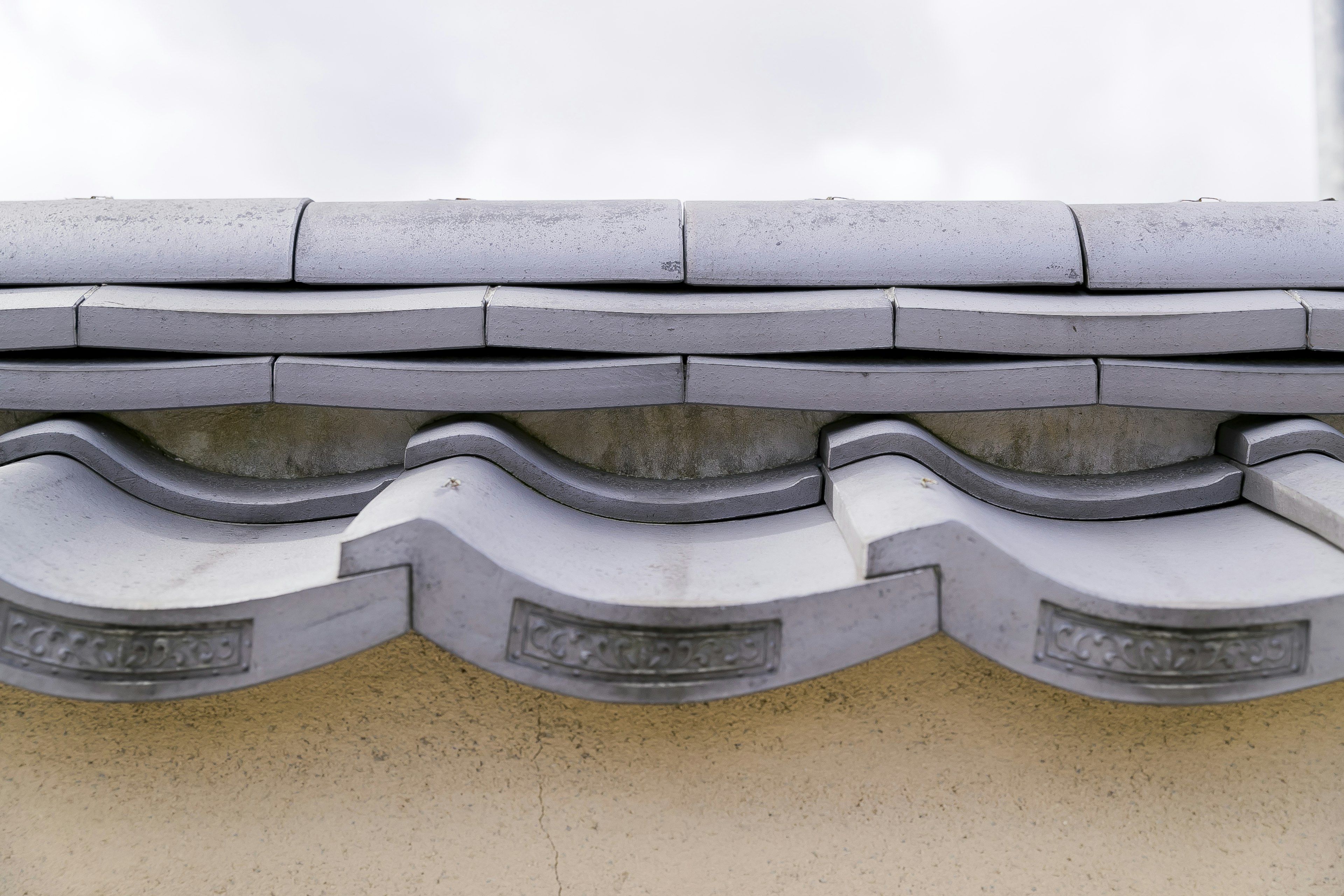 Part of a traditional Japanese tile roof featuring wavy design and gray tones