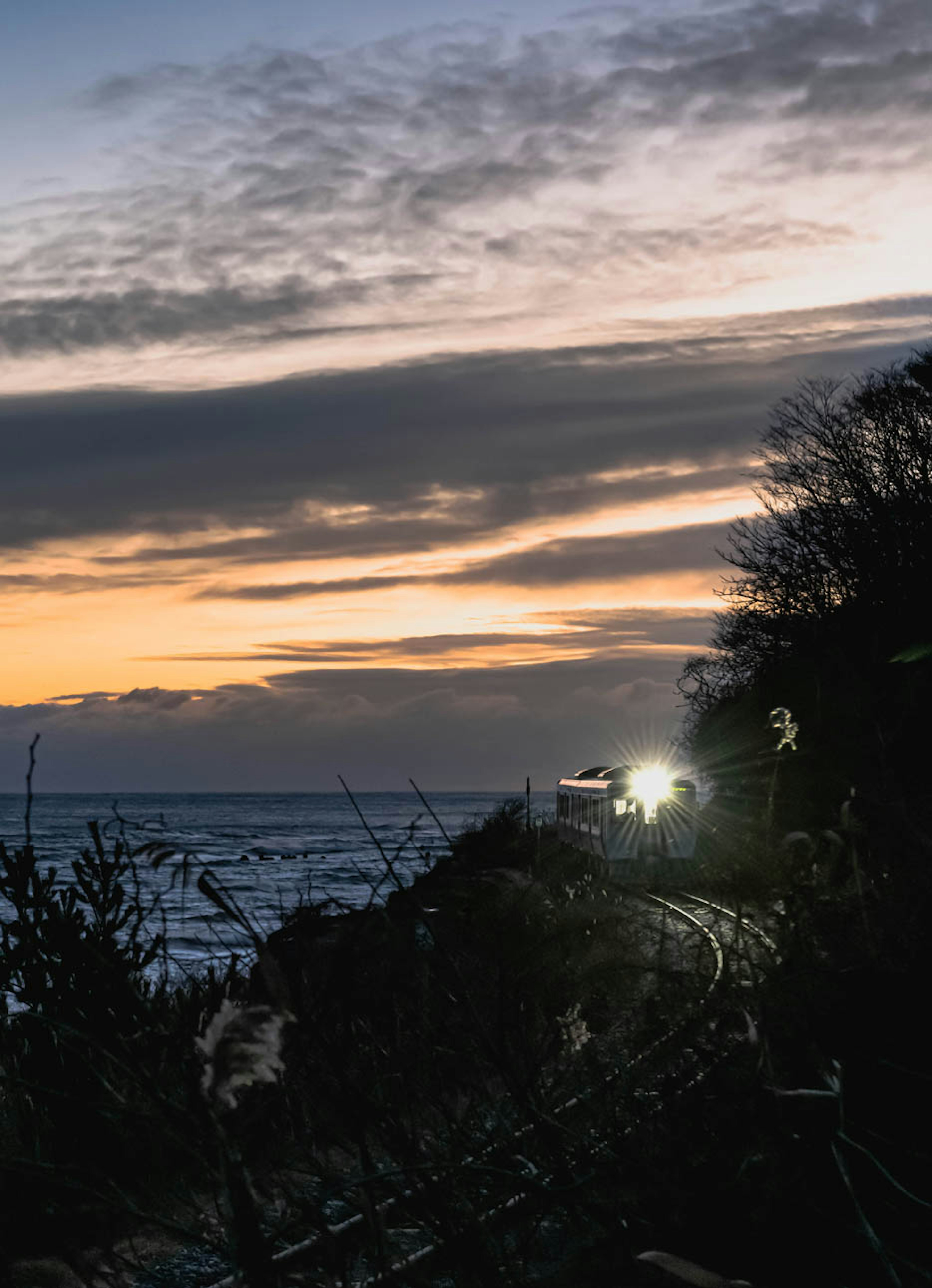 Voie ferrée côtière avec ciel au coucher du soleil