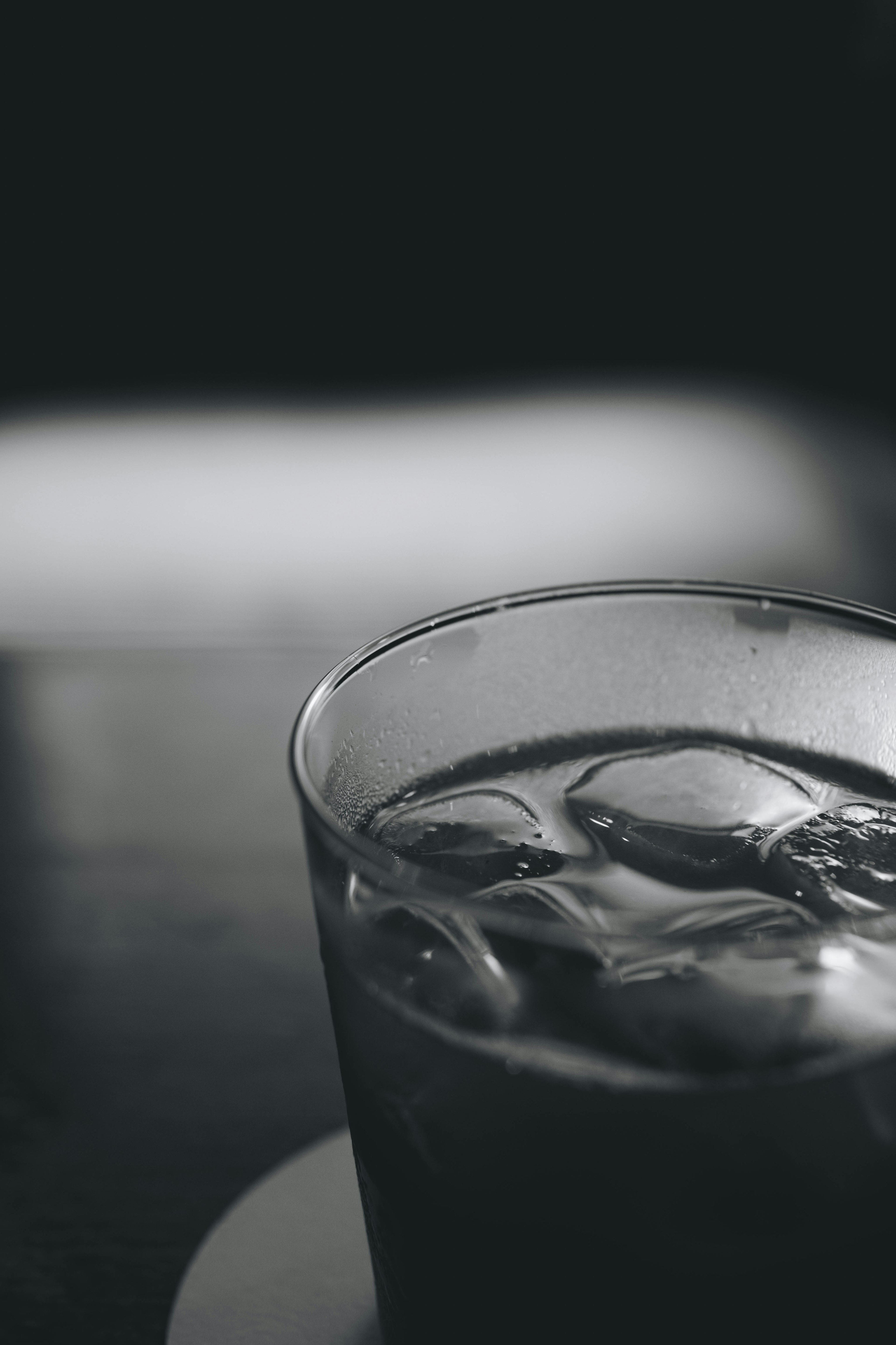 Close-up of a transparent glass with ice cubes and a drink