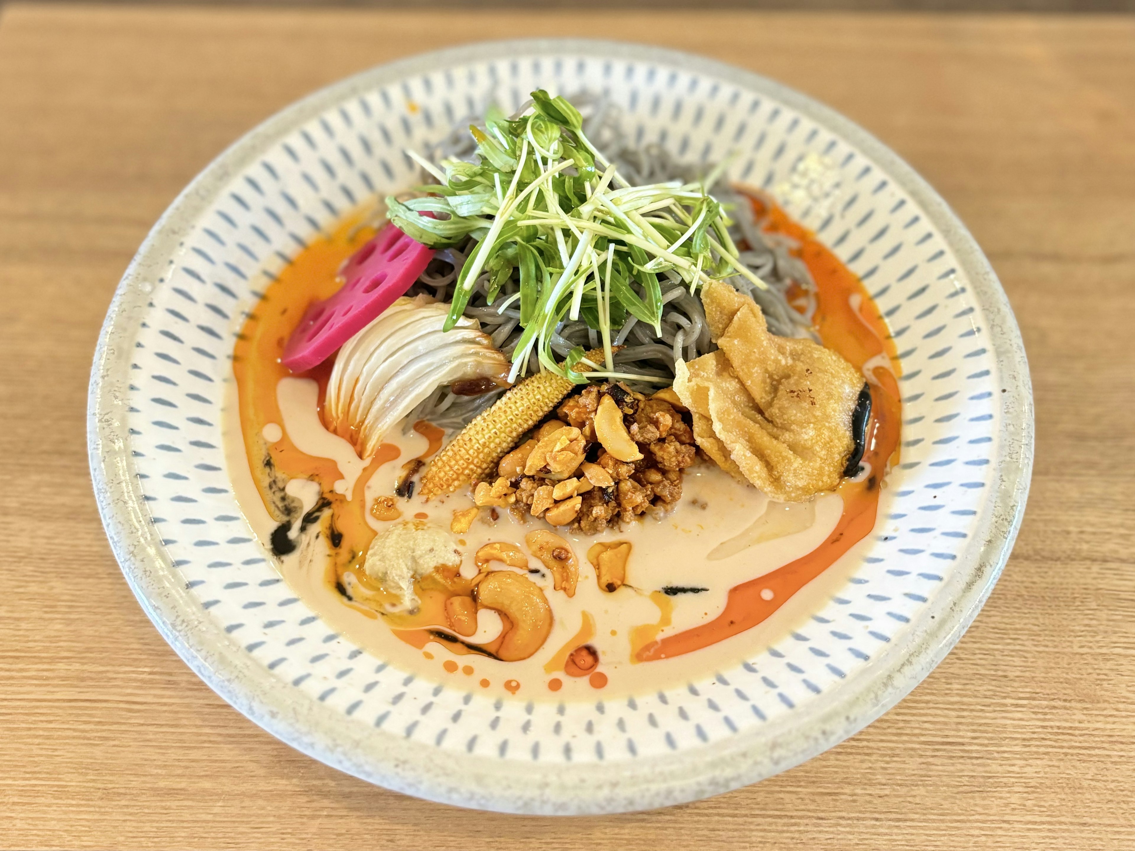 美しい盛り付けの冷やし中華料理　色とりどりのトッピング　スープの上に野菜と肉