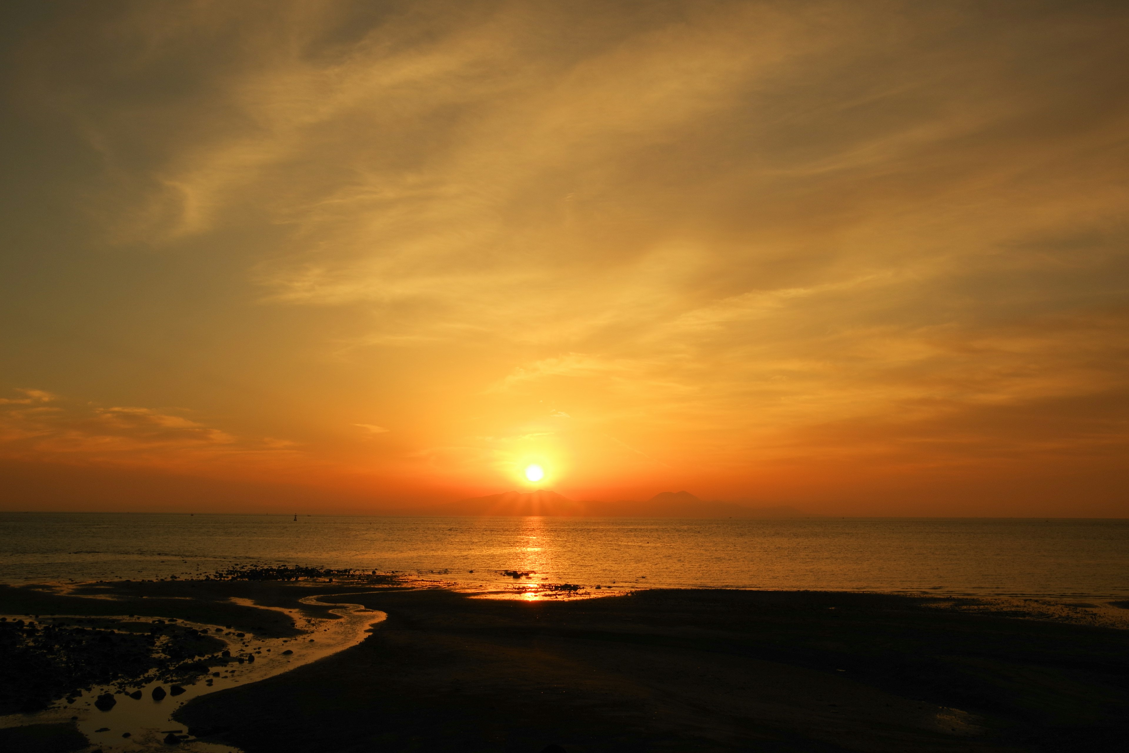 Magnifique coucher de soleil sur l'océan avec un ciel orange et une eau calme