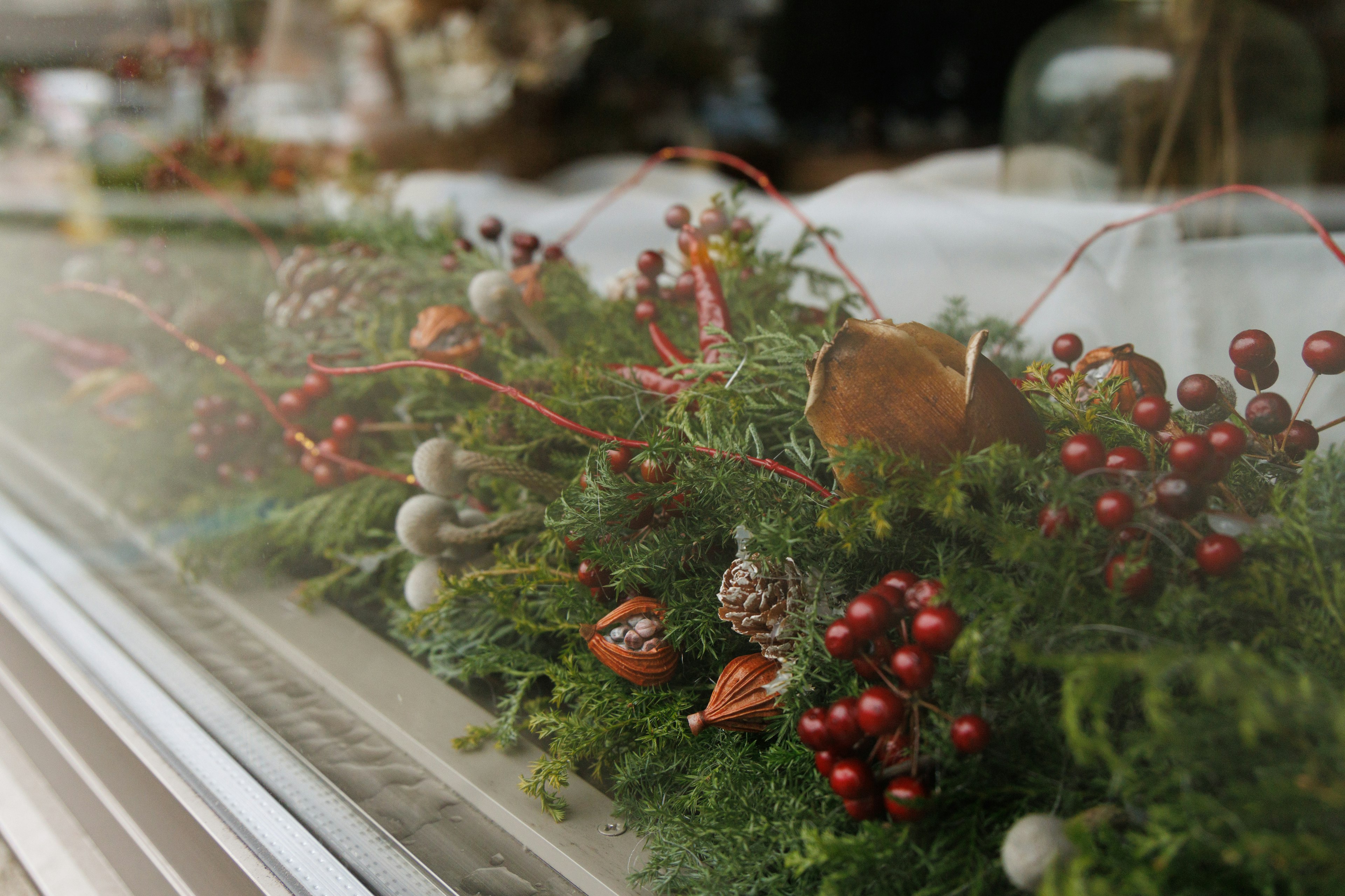 Decorazioni natalizie con verde e bacche rosse su un davanzale