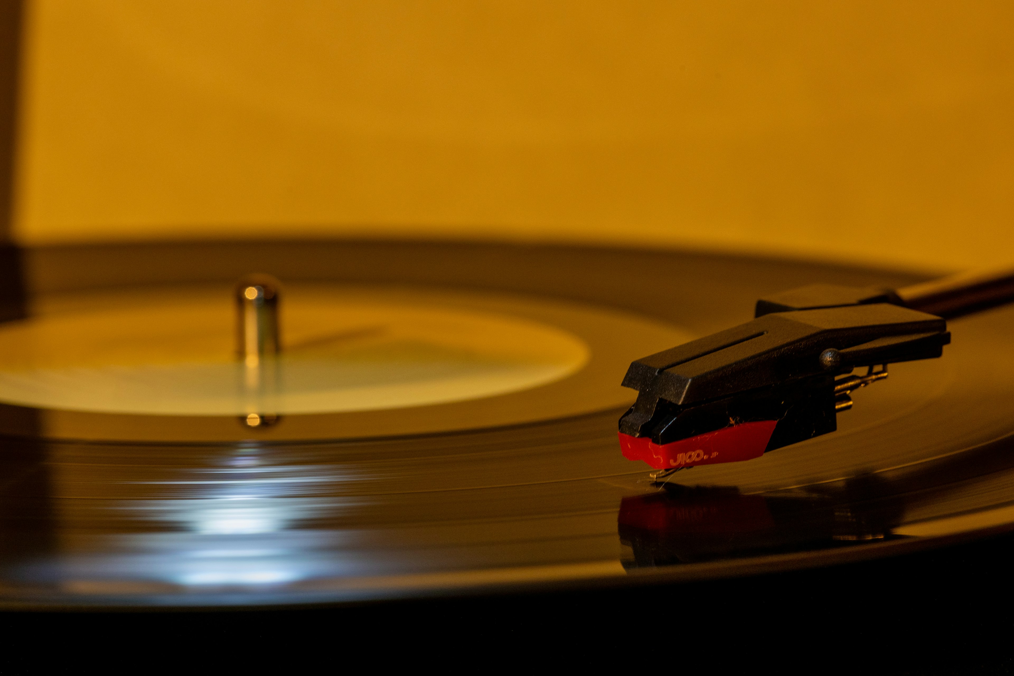 Imagen en primer plano de un disco de vinilo con una aguja de tocadiscos en movimiento