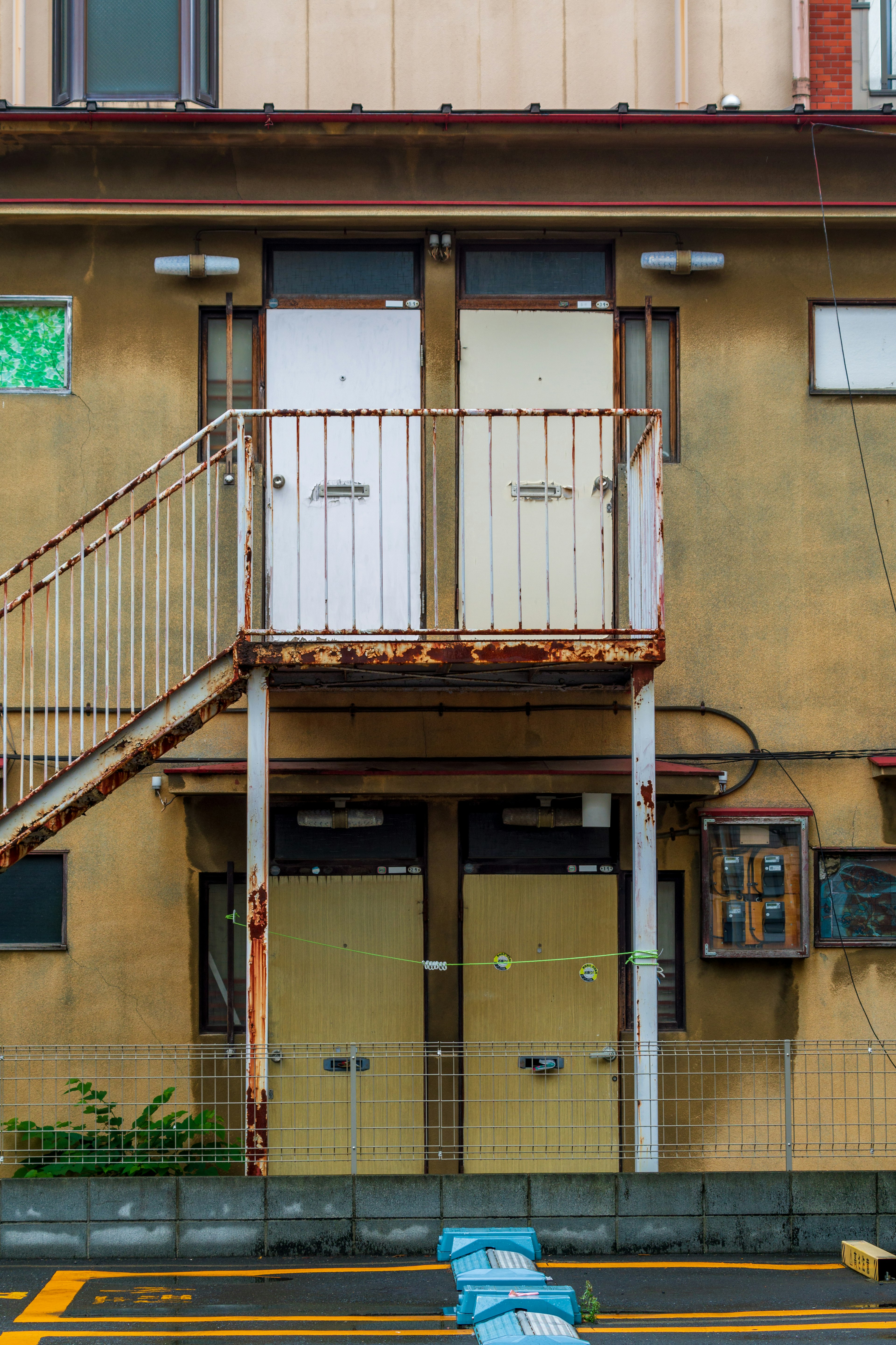 Exterior of an old apartment building with a staircase and entrance doors