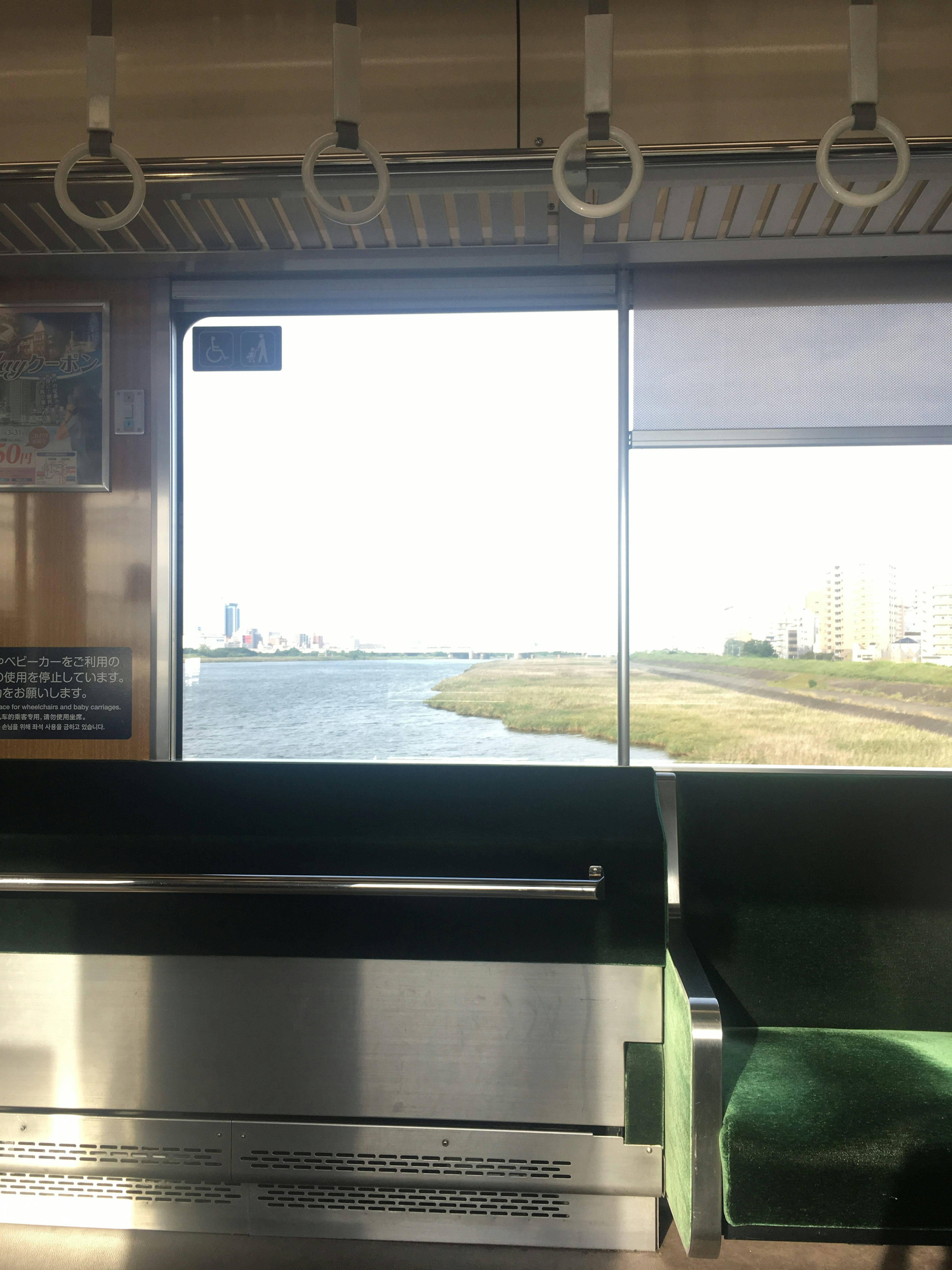 Vue d'une rivière depuis l'intérieur d'un train avec des sièges verts