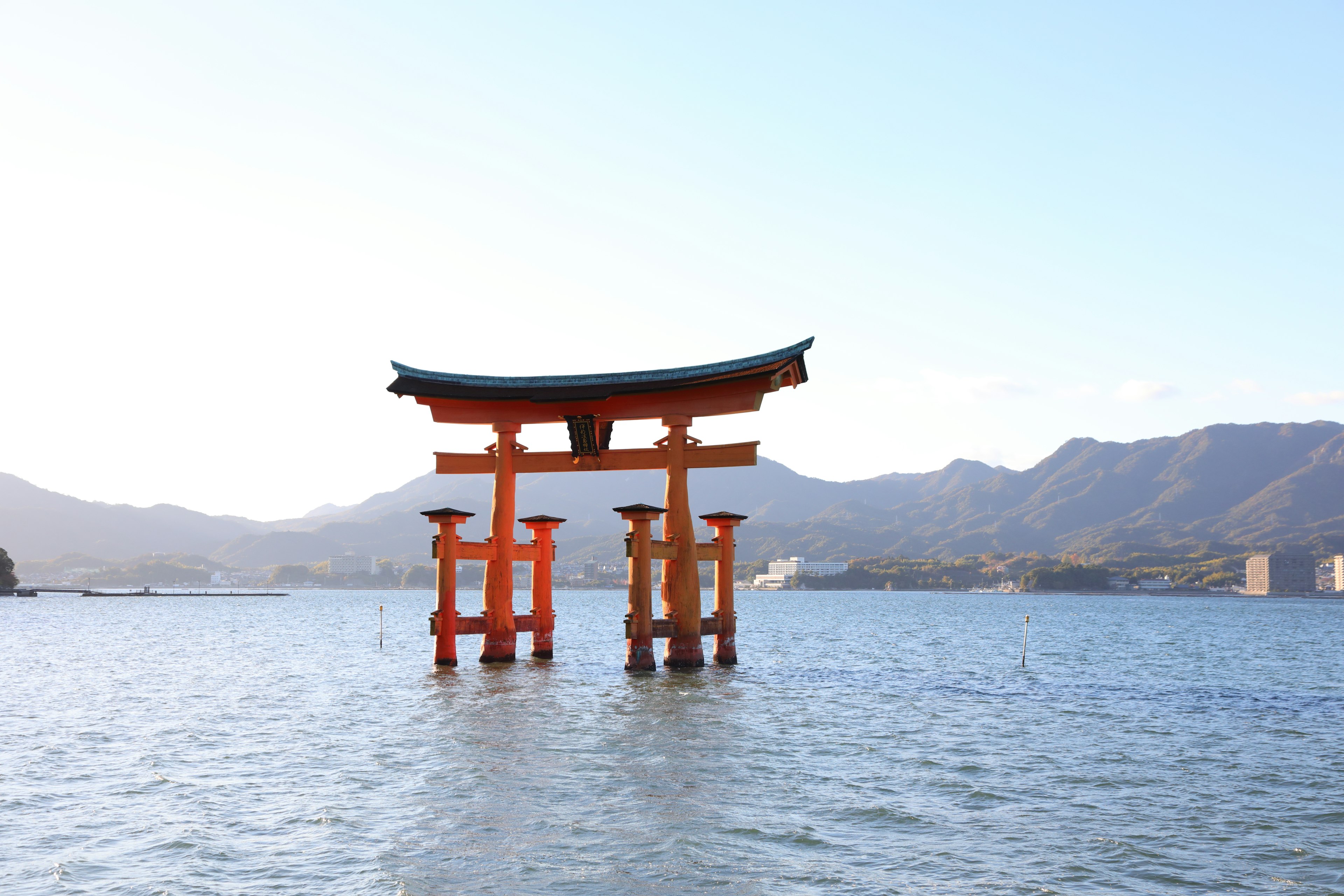 Torii gate in water with mountains in the background