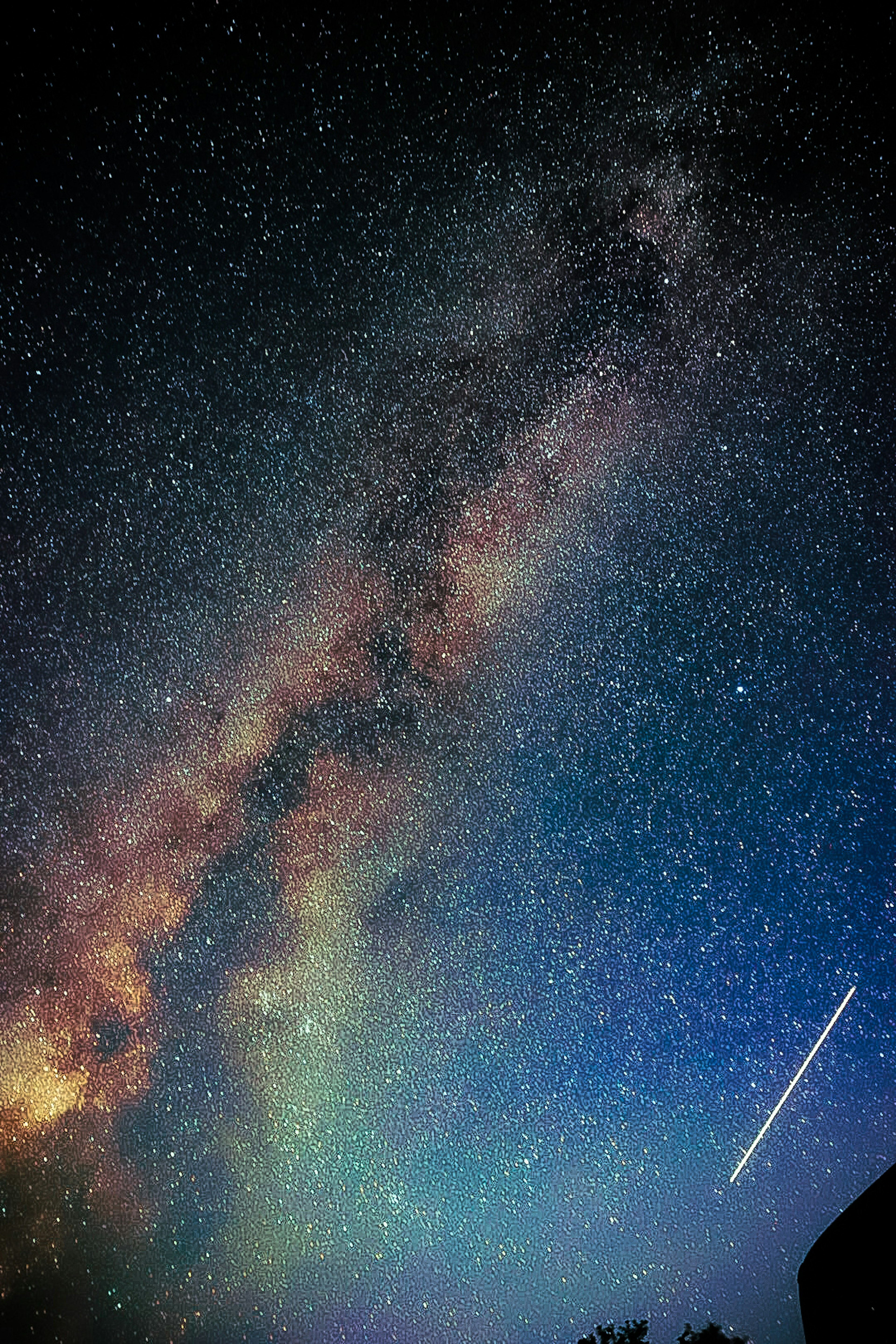 Vista mozzafiato della galassia della Via Lattea in un cielo stellato con una stella cadente