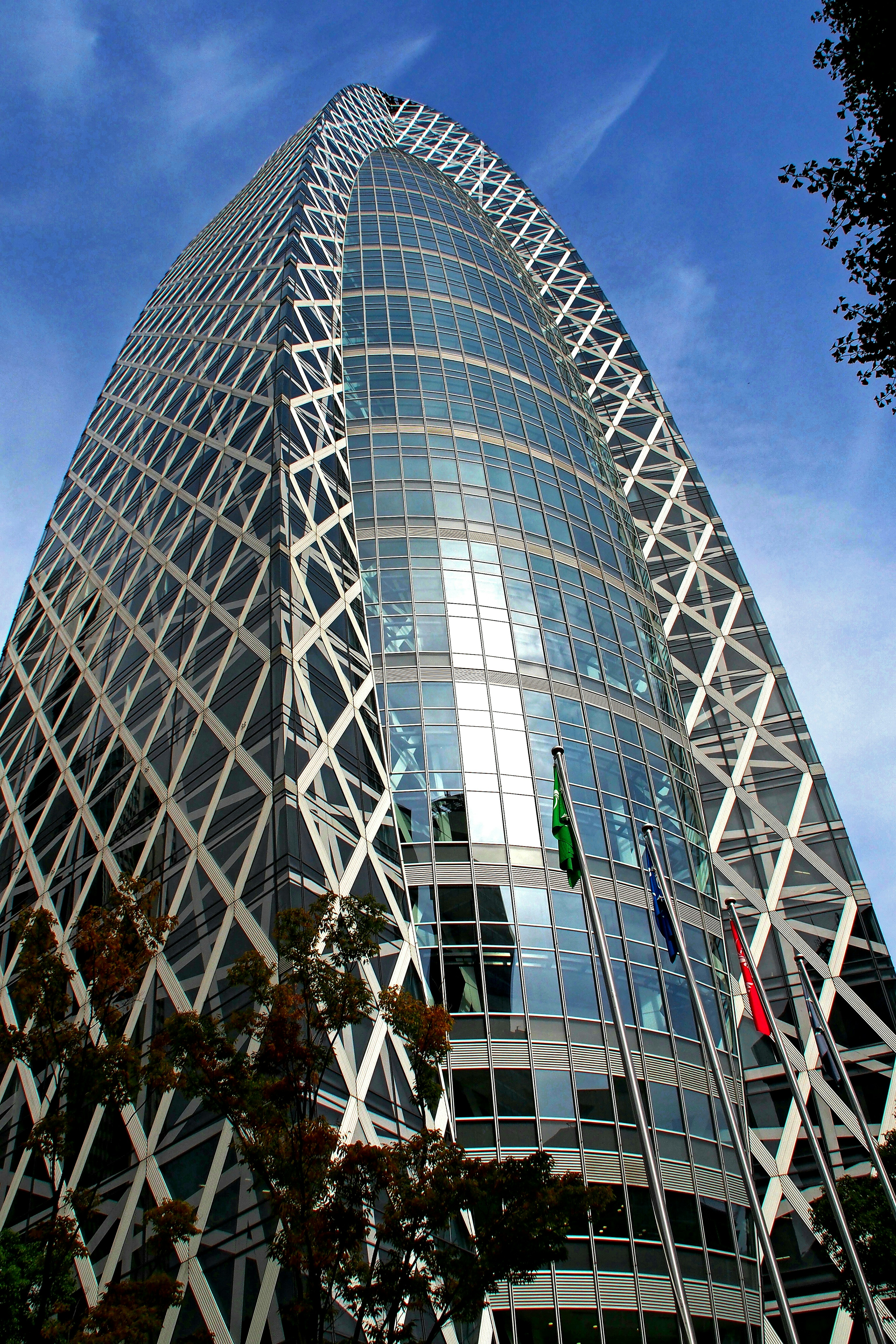 Moderne Hochhausfassade aus Glas und Metall unter blauem Himmel