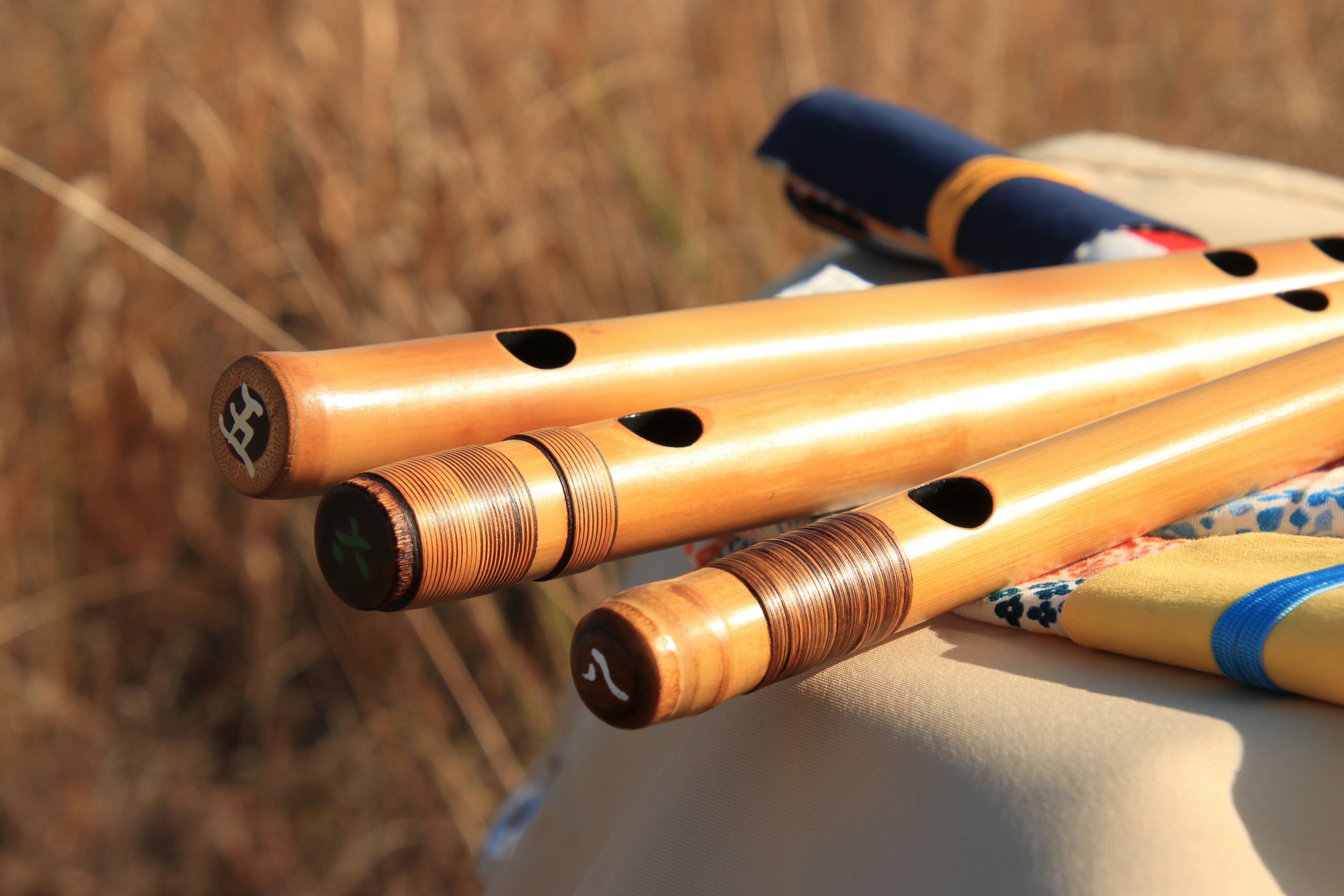 Wooden flutes placed on a surface in a grassy field