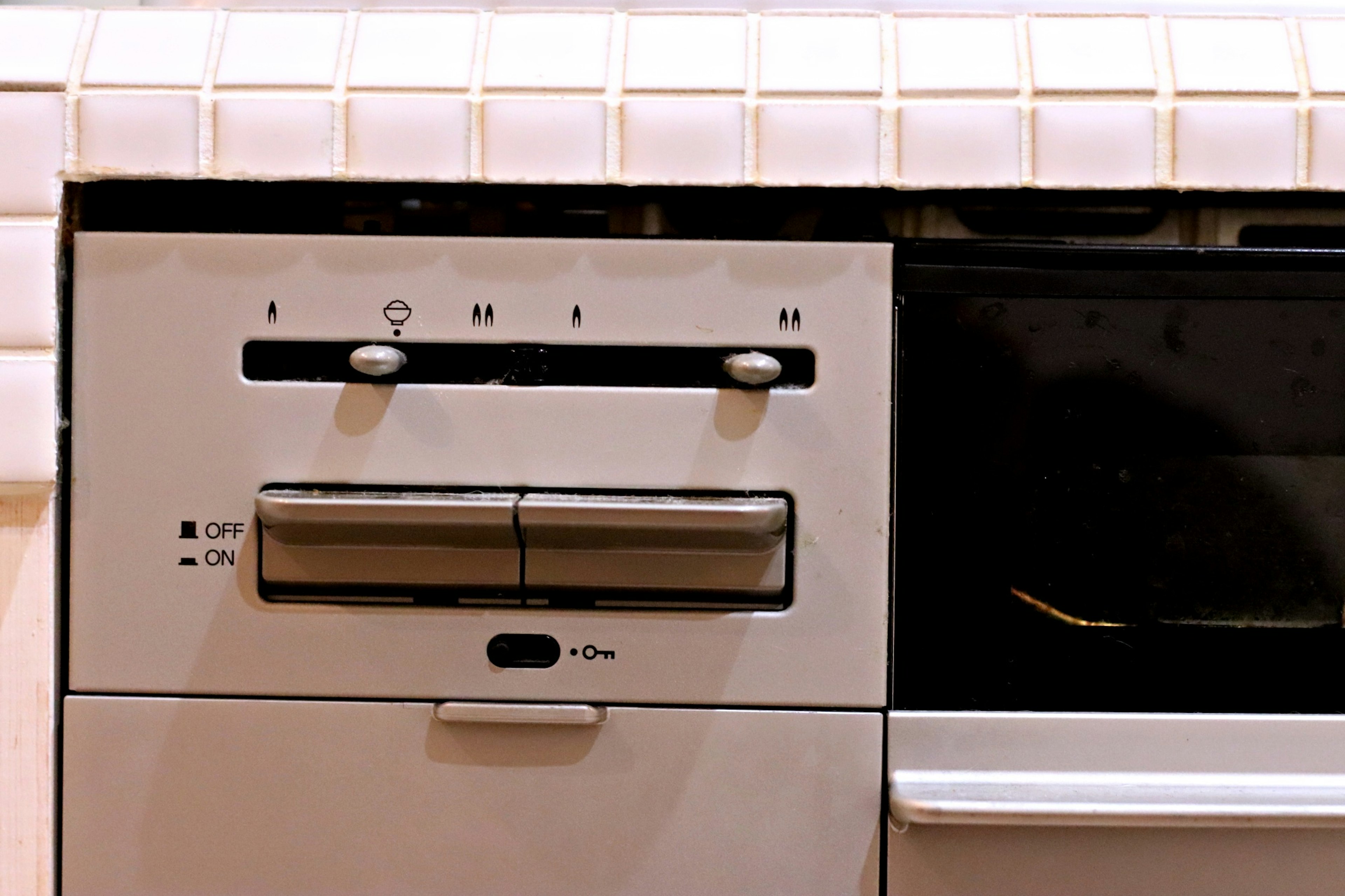 Compact control panel of a kitchen appliance featuring buttons and a drawer