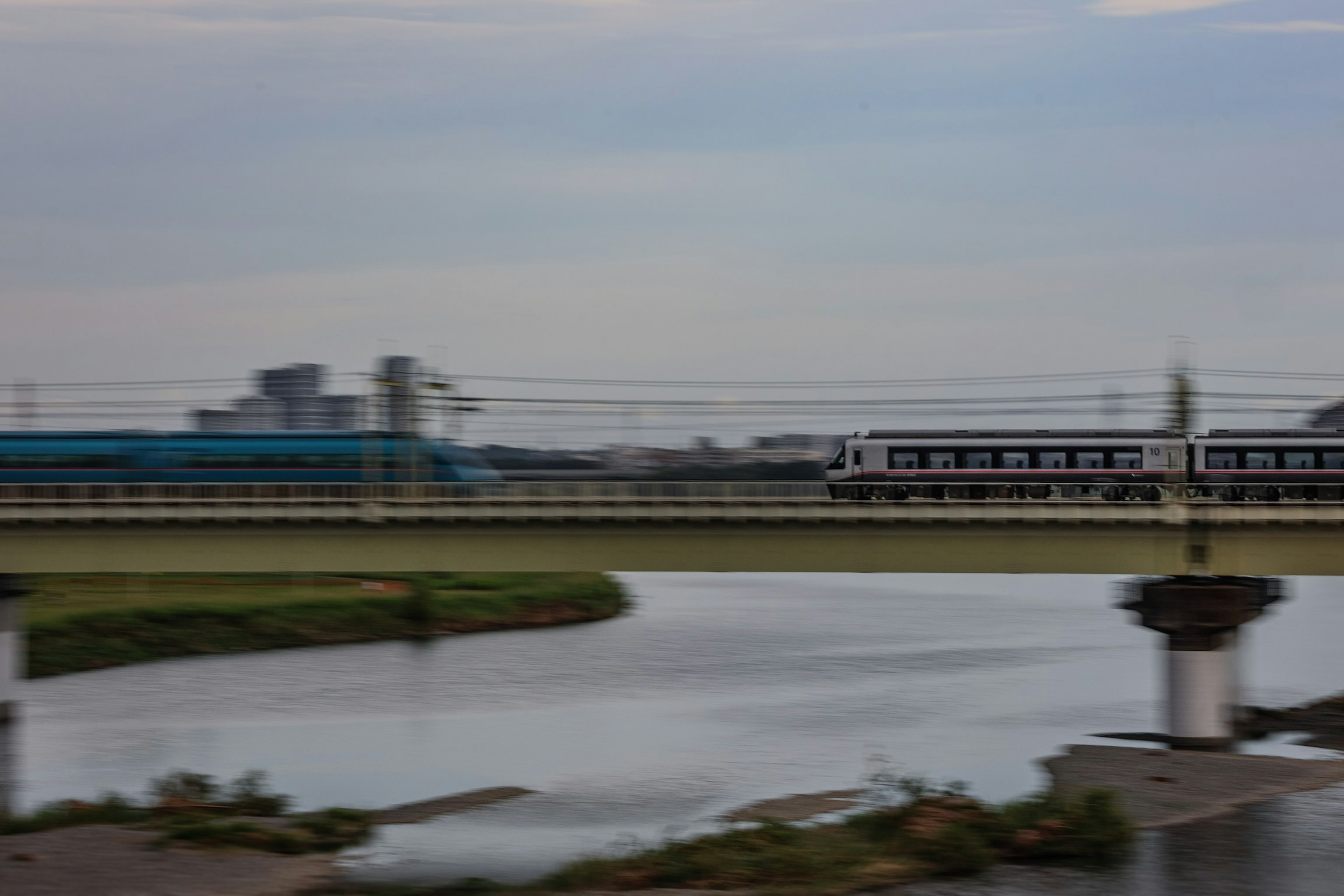 Zug überquert eine Brücke mit Blick auf den Fluss