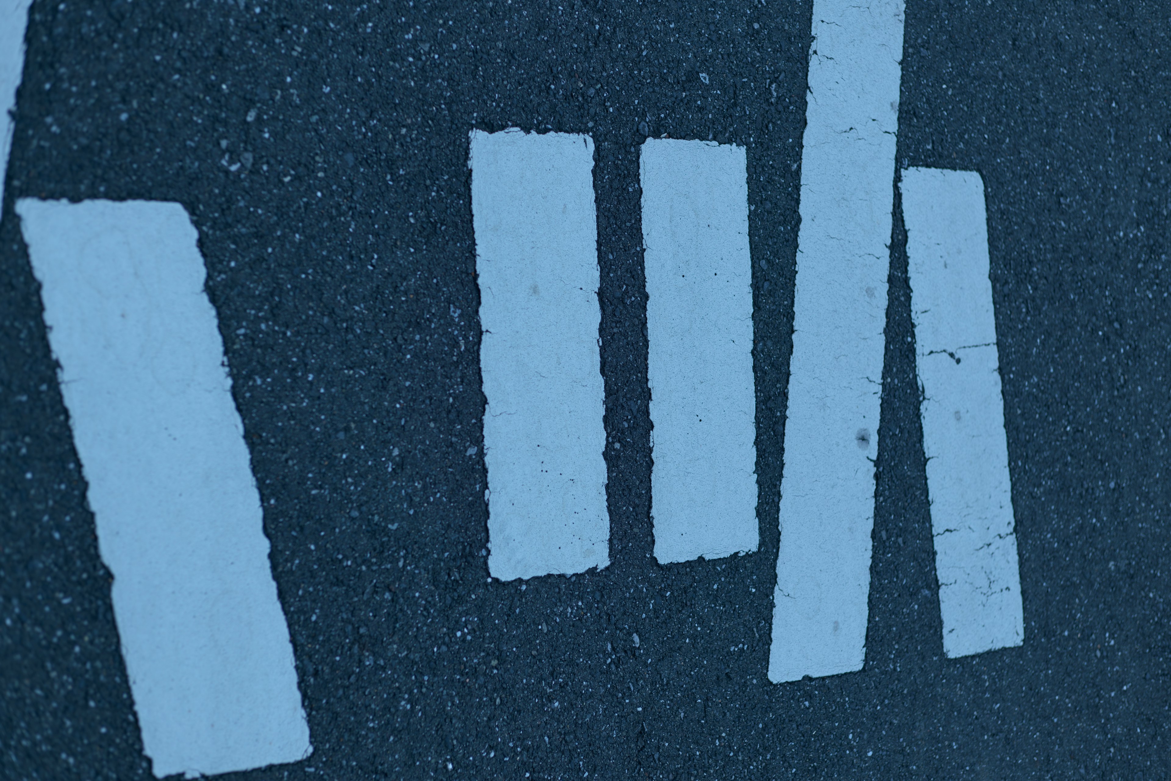 Close-up of white crosswalk markings on asphalt