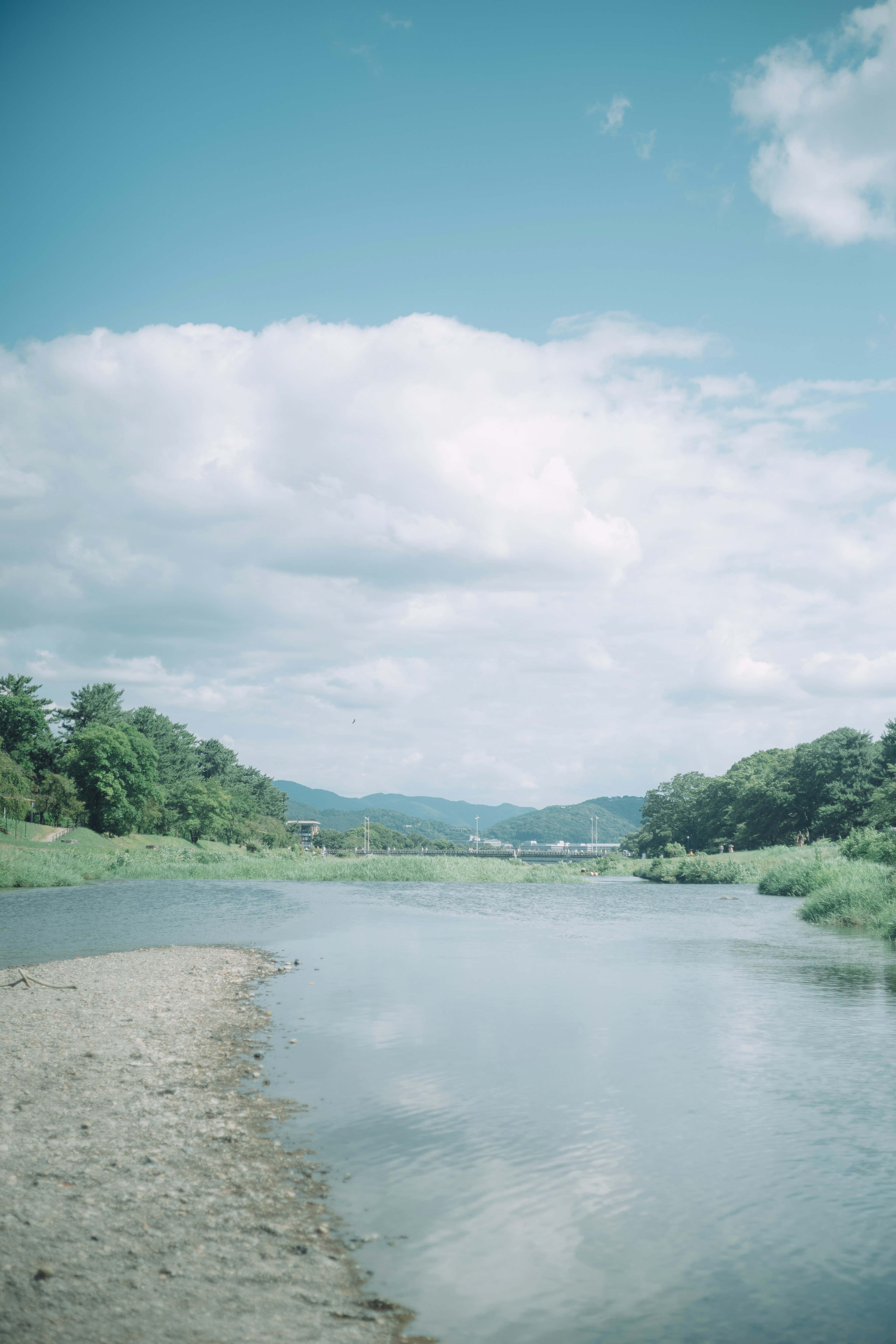 Scenic river landscape with blue sky and clouds lush greenery and sandy shore