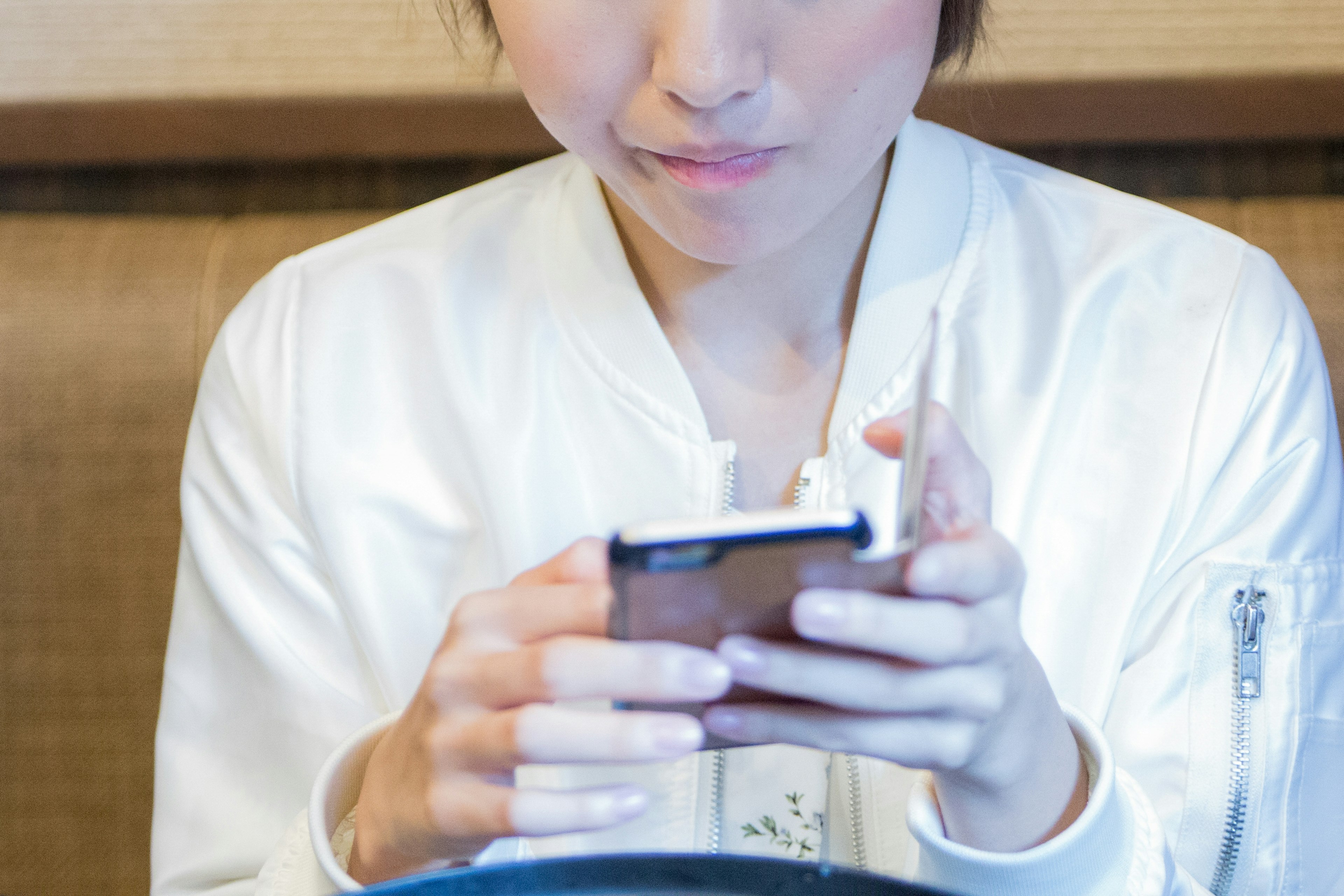 A woman using a smartphone while sitting at a table