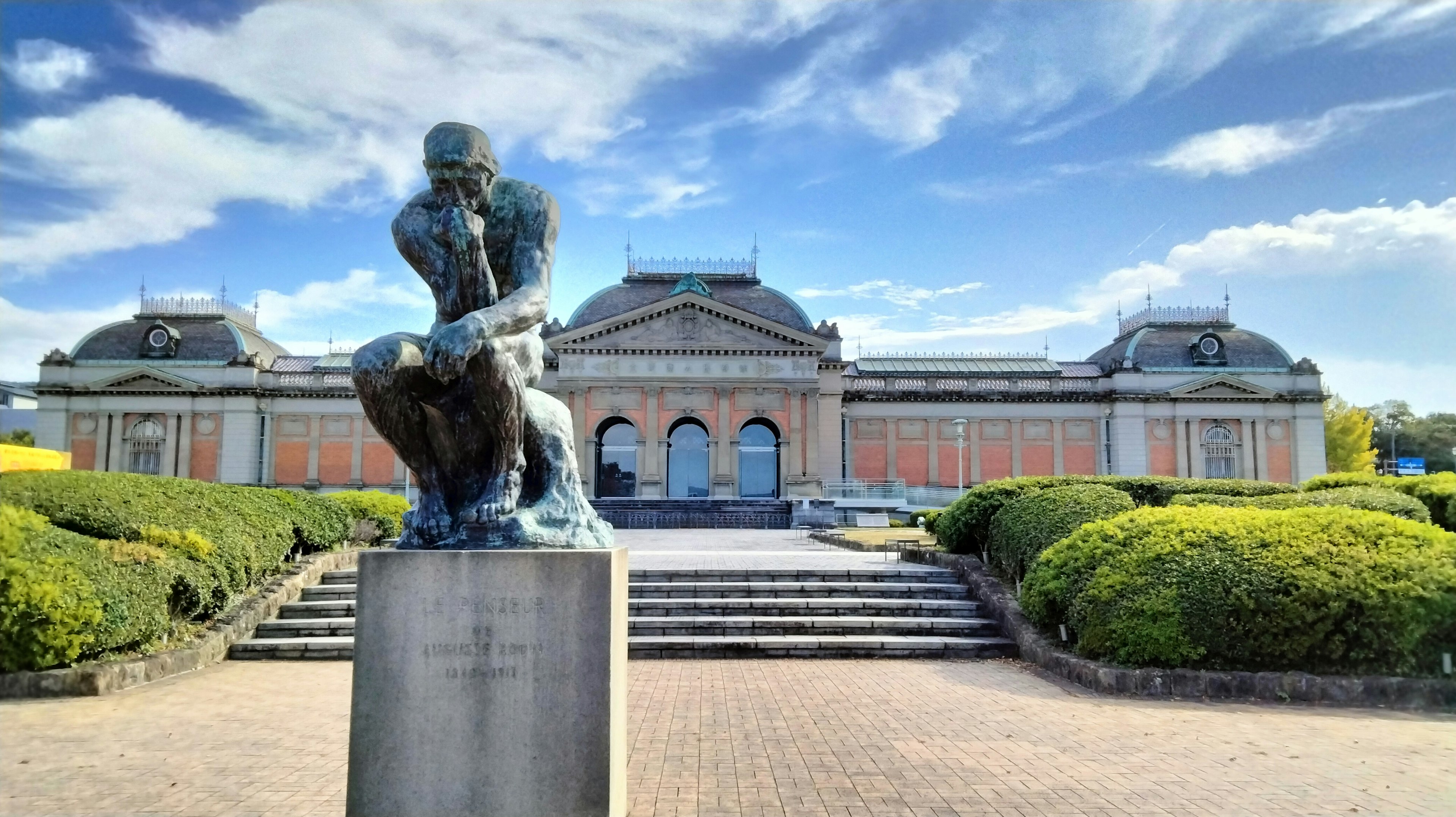 La escultura El Pensador frente a un majestuoso edificio del museo