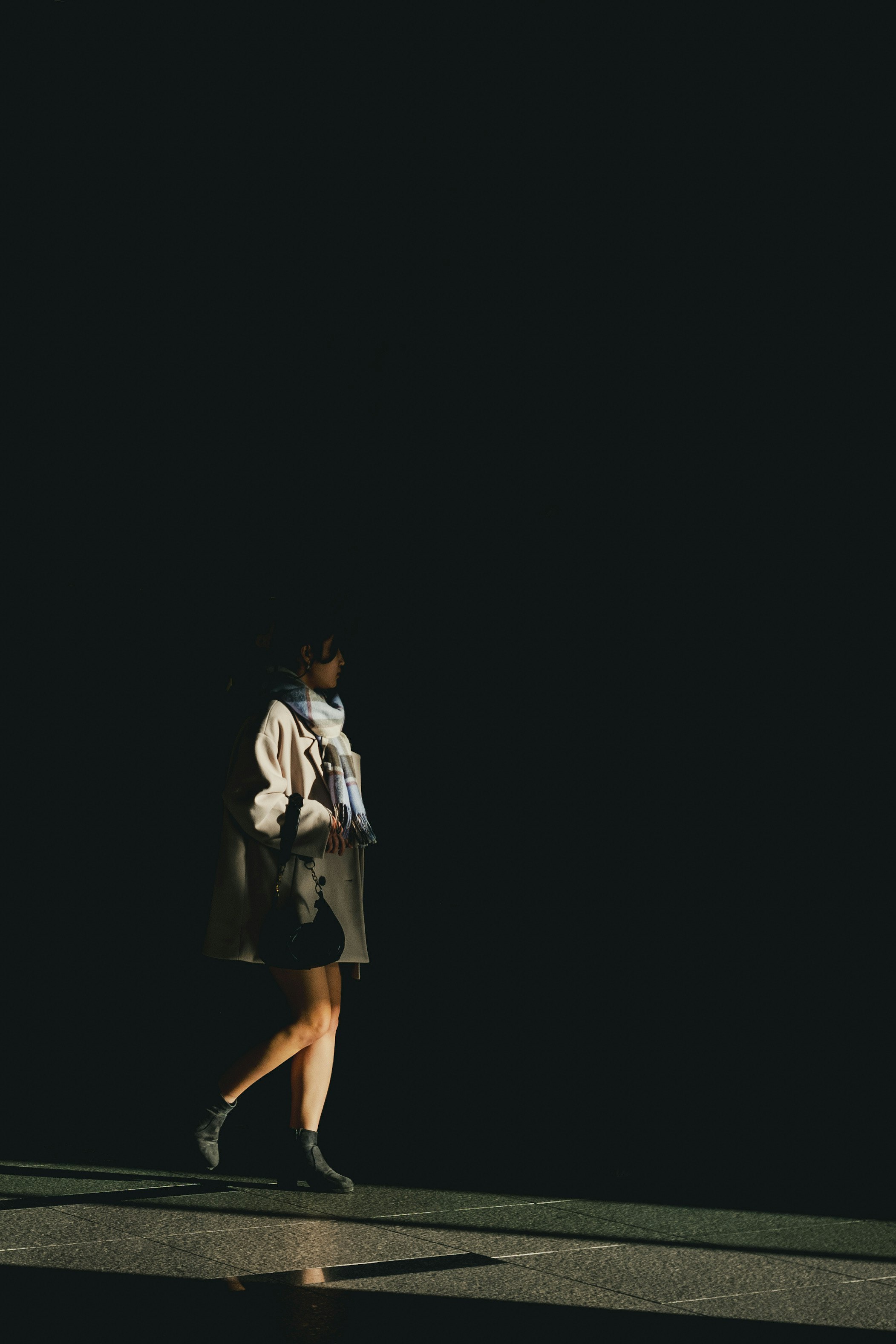 Silhouette of a woman walking against a dark background
