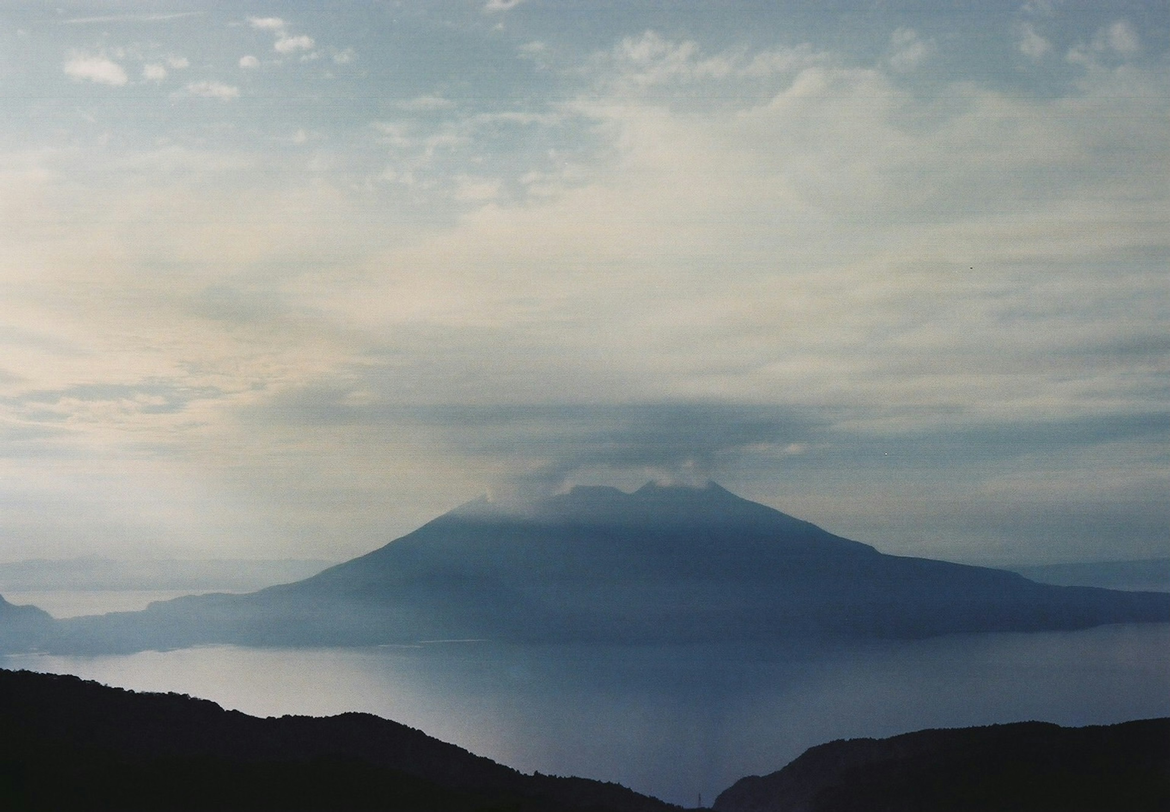 Scenic view of a volcanic mountain surrounded by clouds